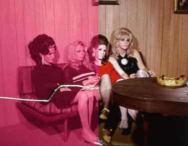 Four 1960s trans women sitting on a sofa.