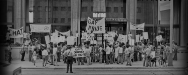 Demonstrators holding signs for gay rights.
