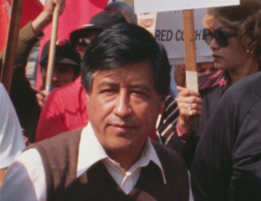Cesar Chavez standing in front of picketers.