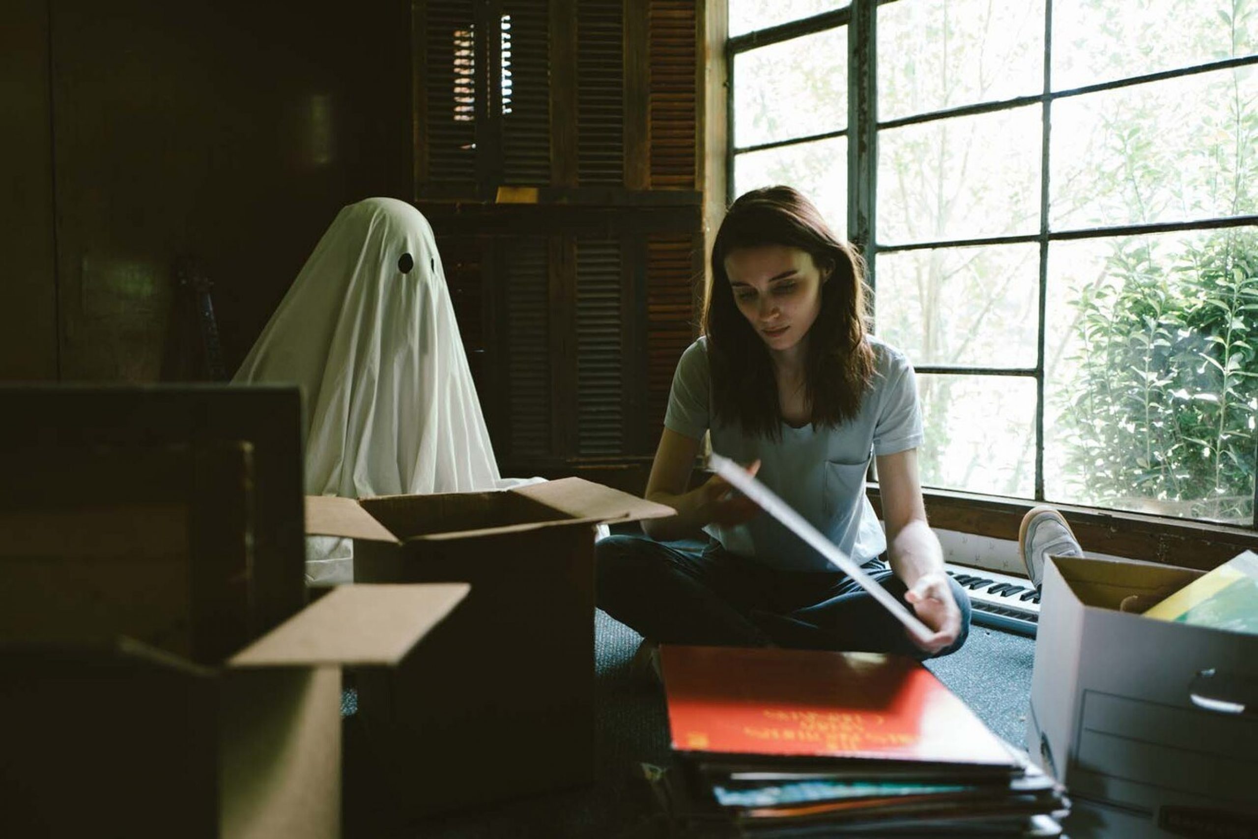 a woman and a ghost looking through boxes