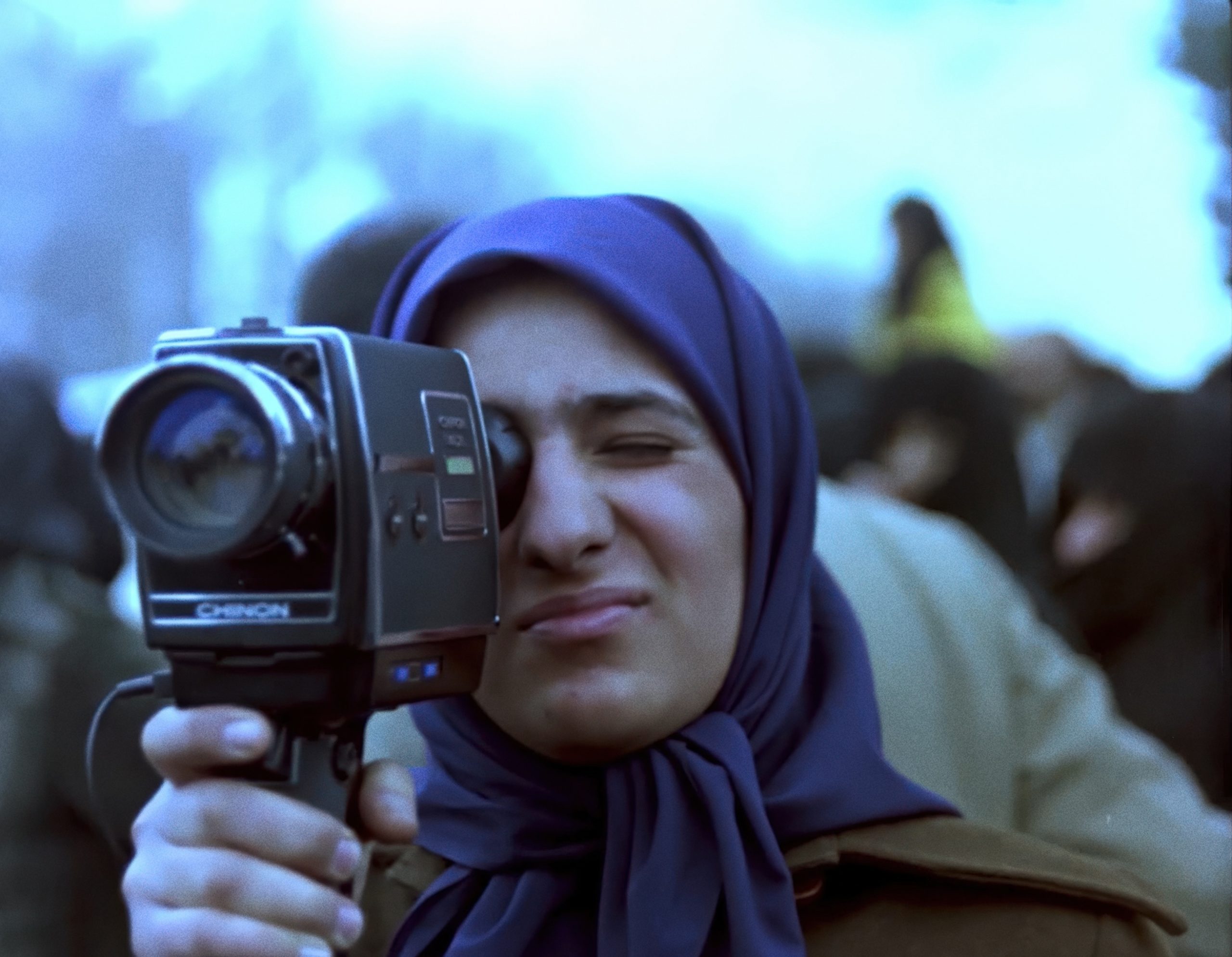 a woman holding a film camera