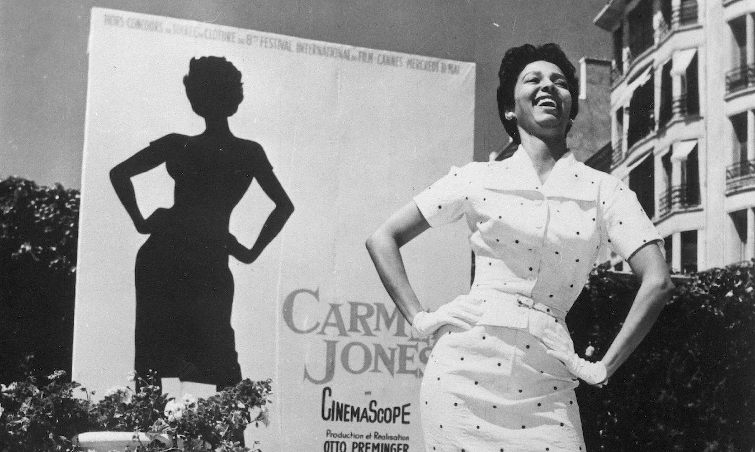 dorothy dandridge standing next to a movie poster for carmen jones