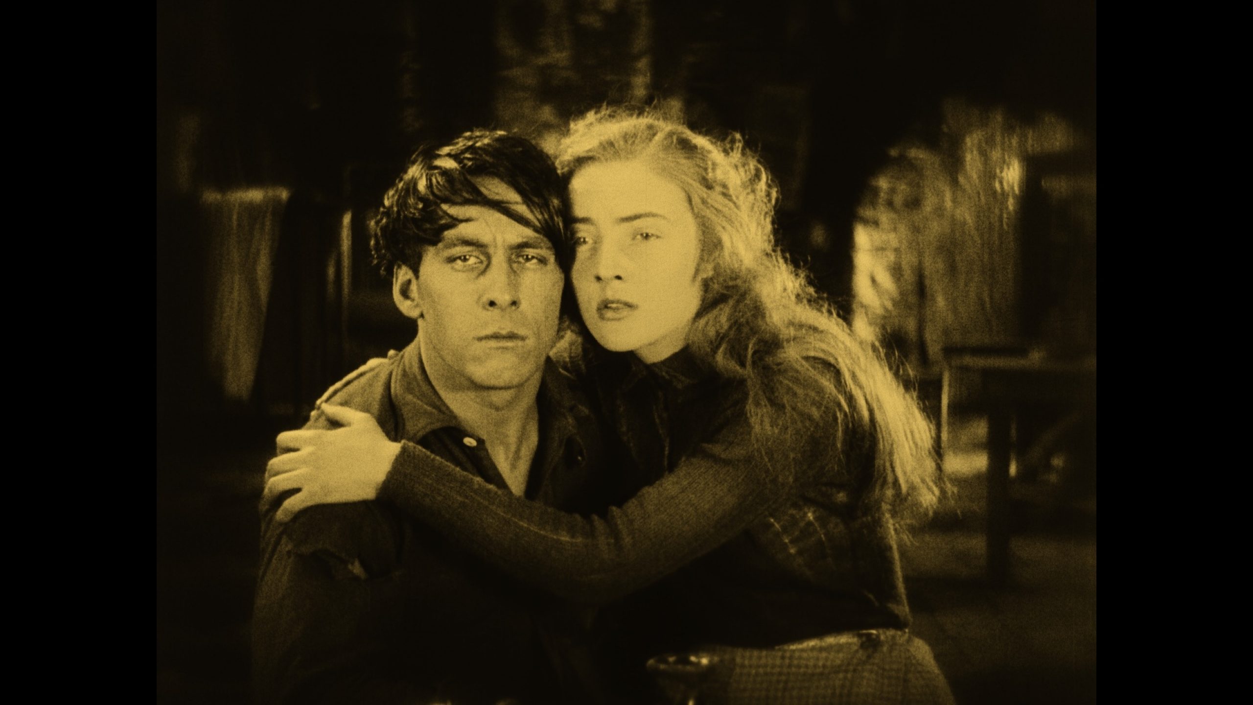 An unhappy looking man and woman. The woman is putting her arm around the man.