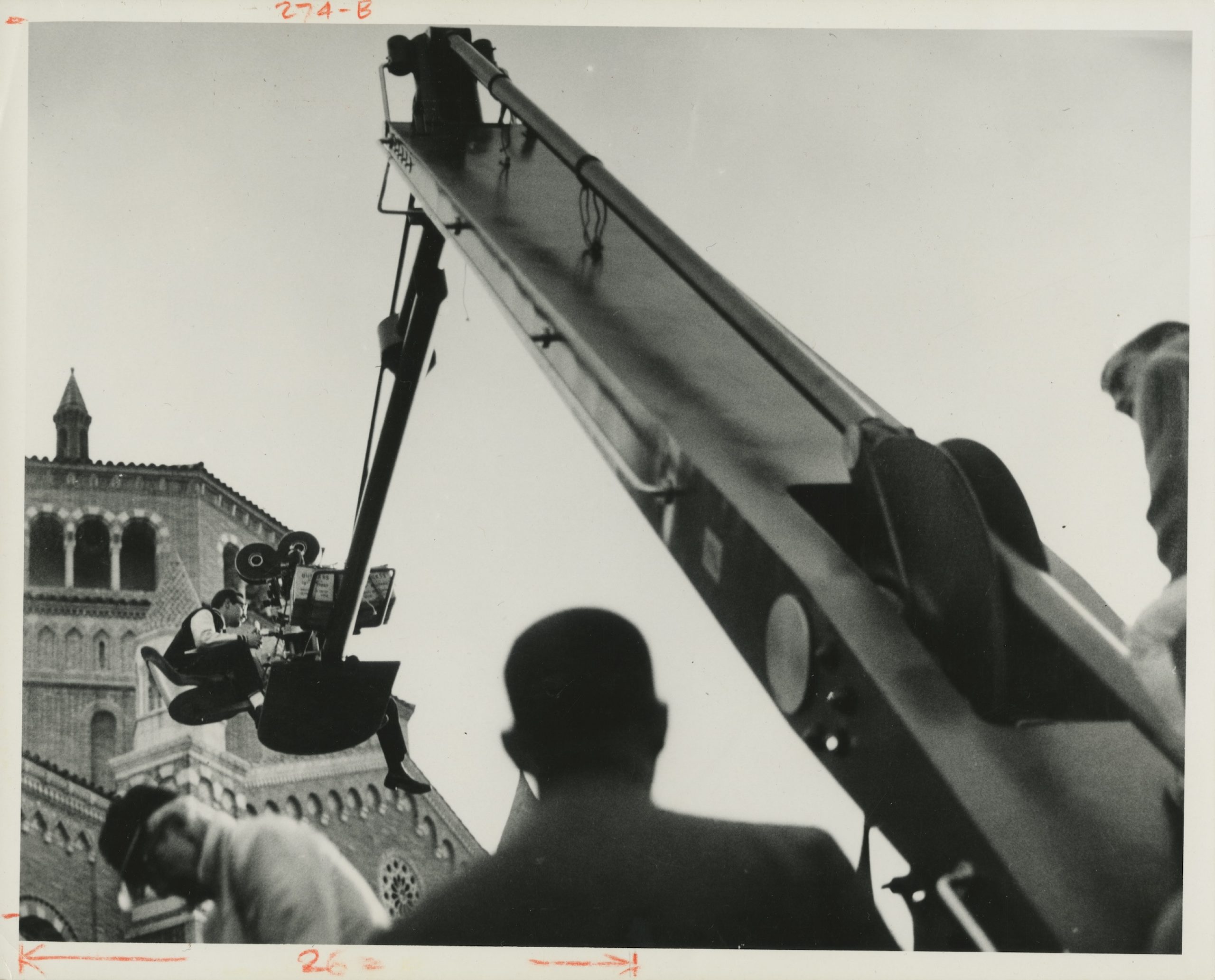 A person operating a camera on a crane at the UCLA campus.