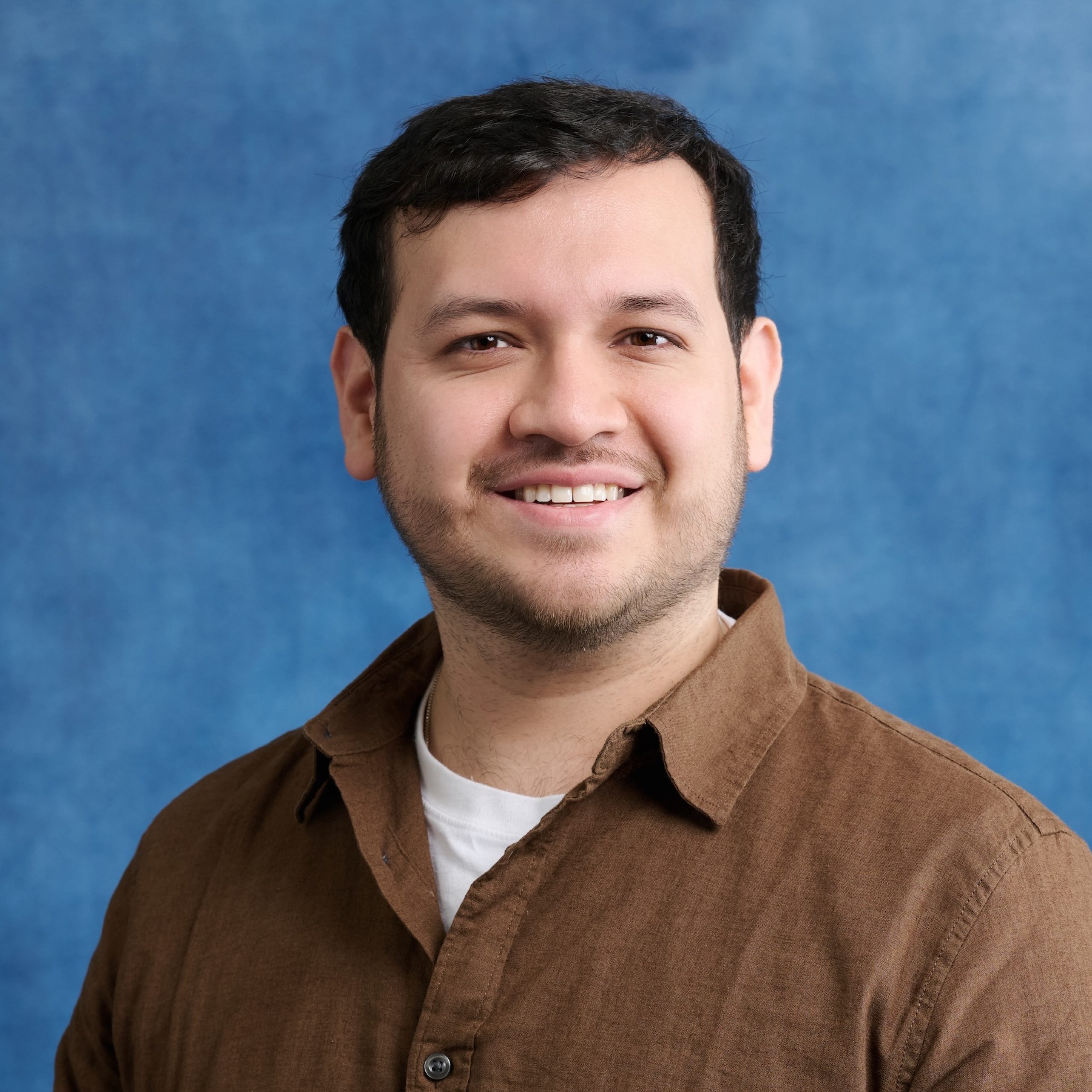 Carlos Diaz wearing a brown collared shirt
