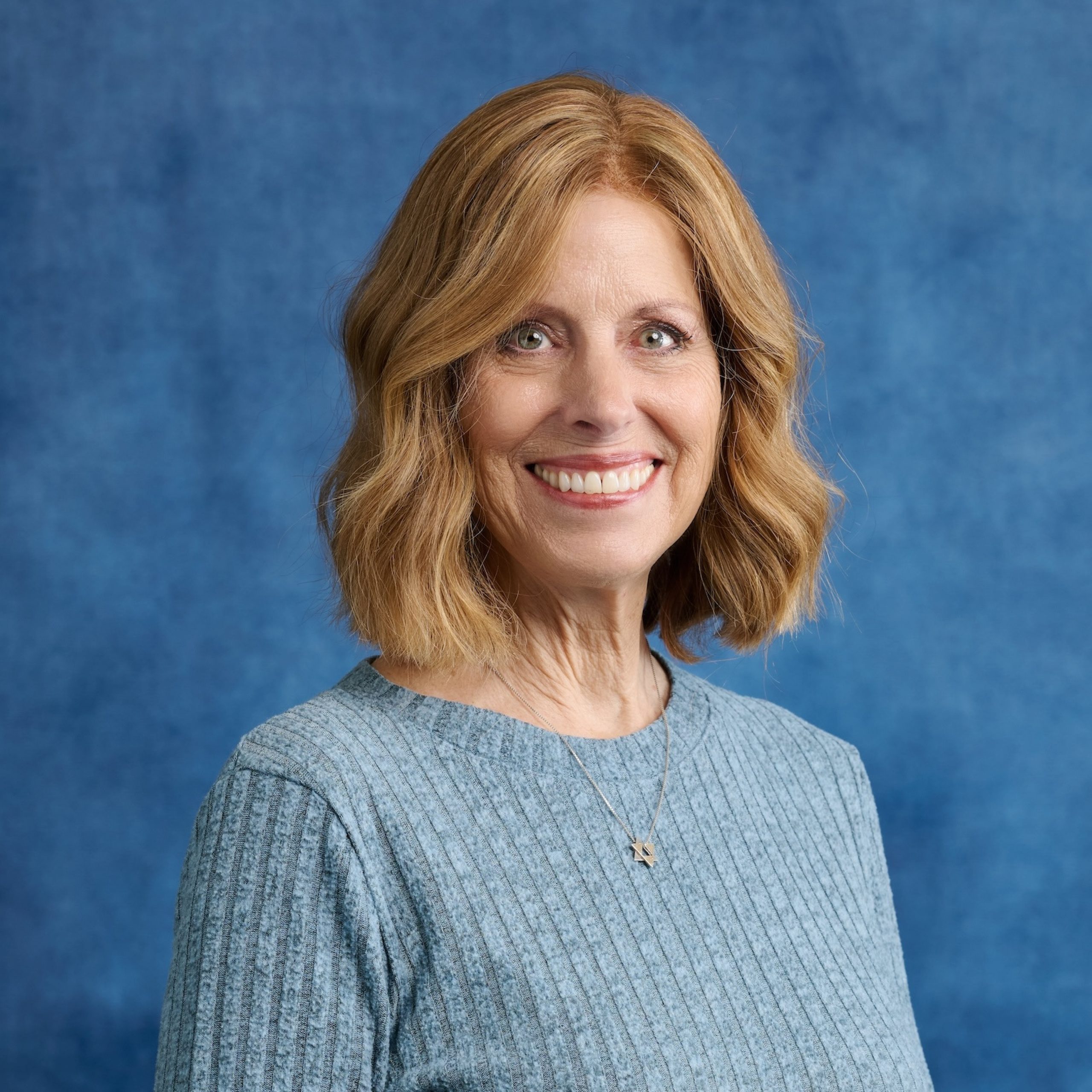 Diane Mizrachi headshot wearing blue top