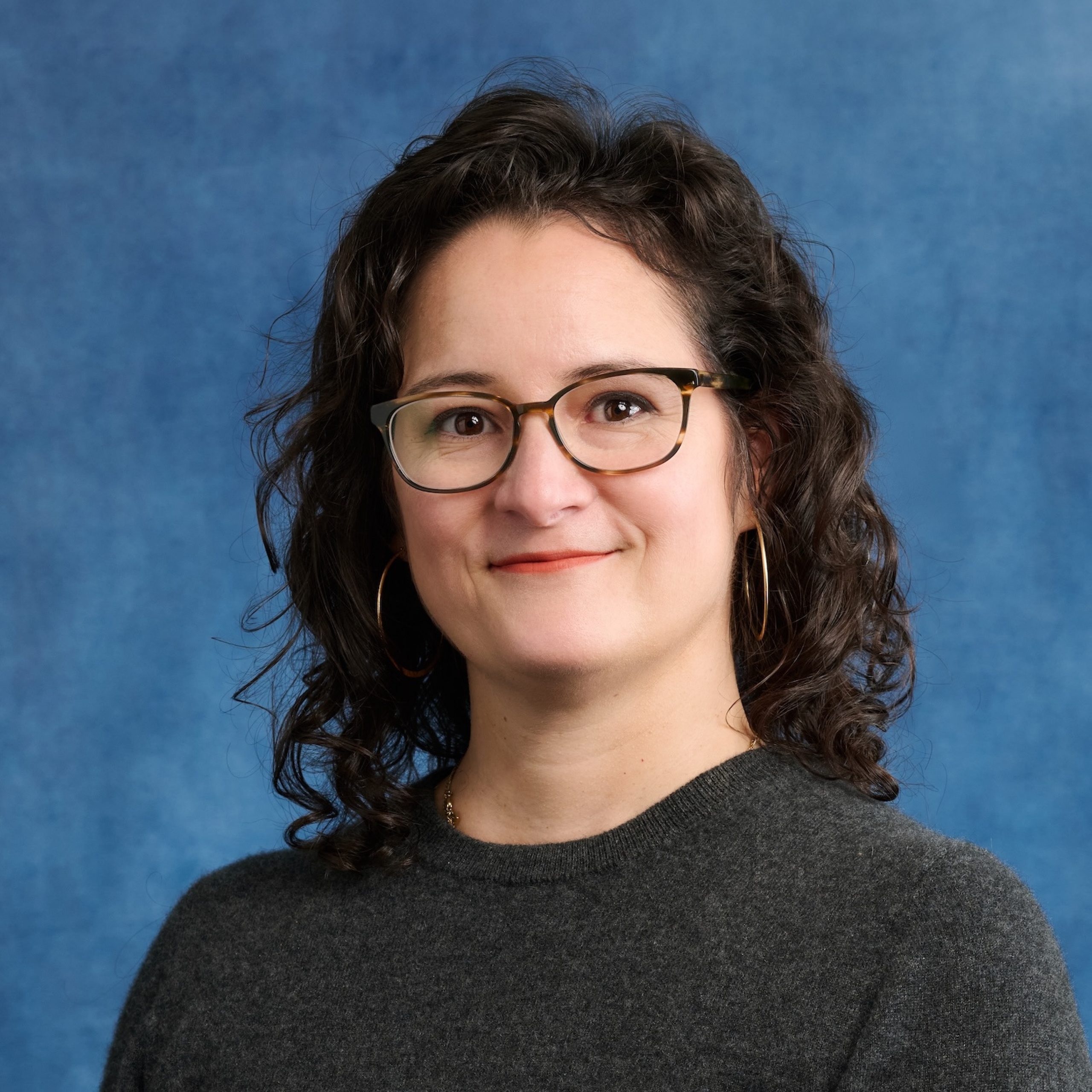 Jessica Viada headshot wearing a dark top and glasses