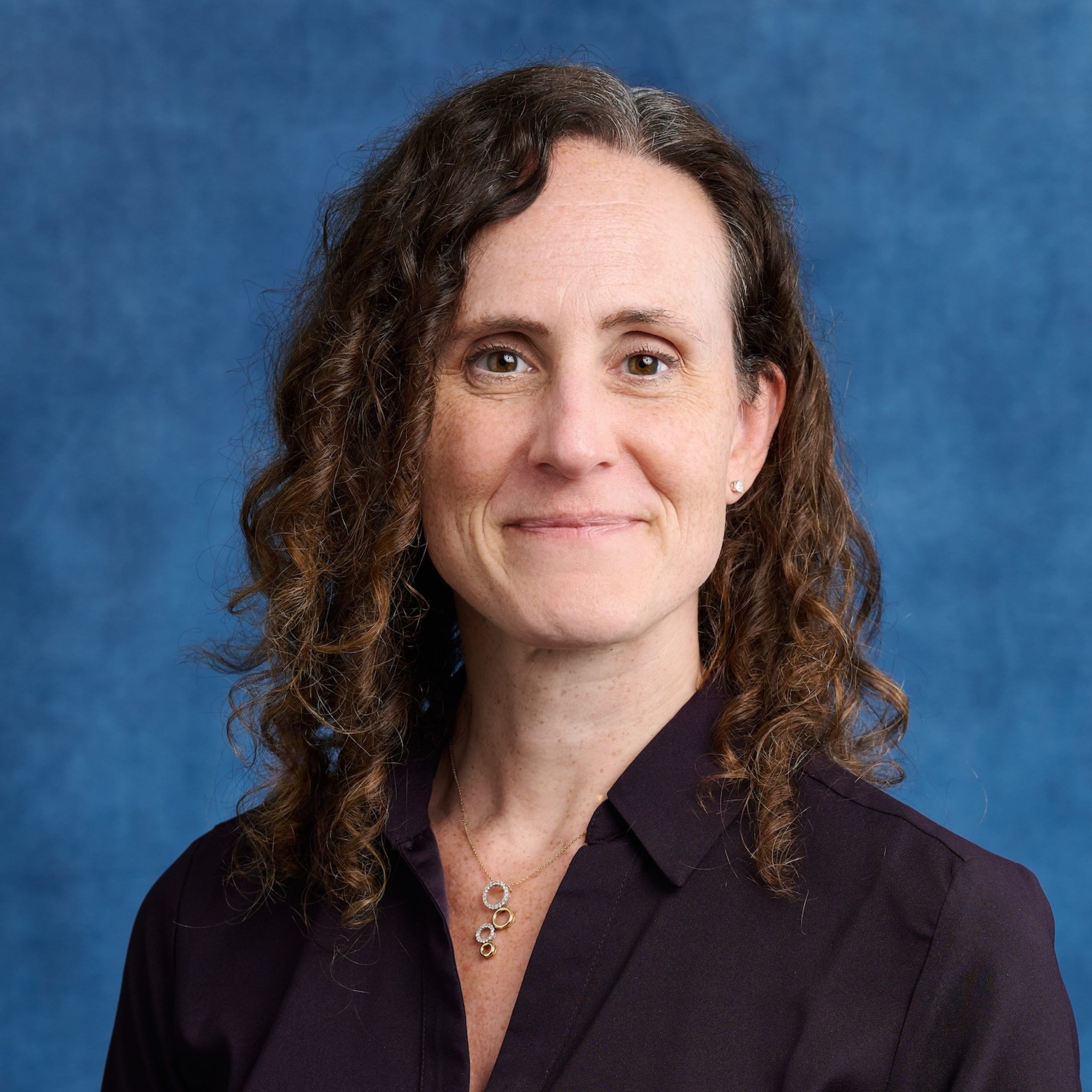 Allison Benedetti headshot wearing a dark collared shirt