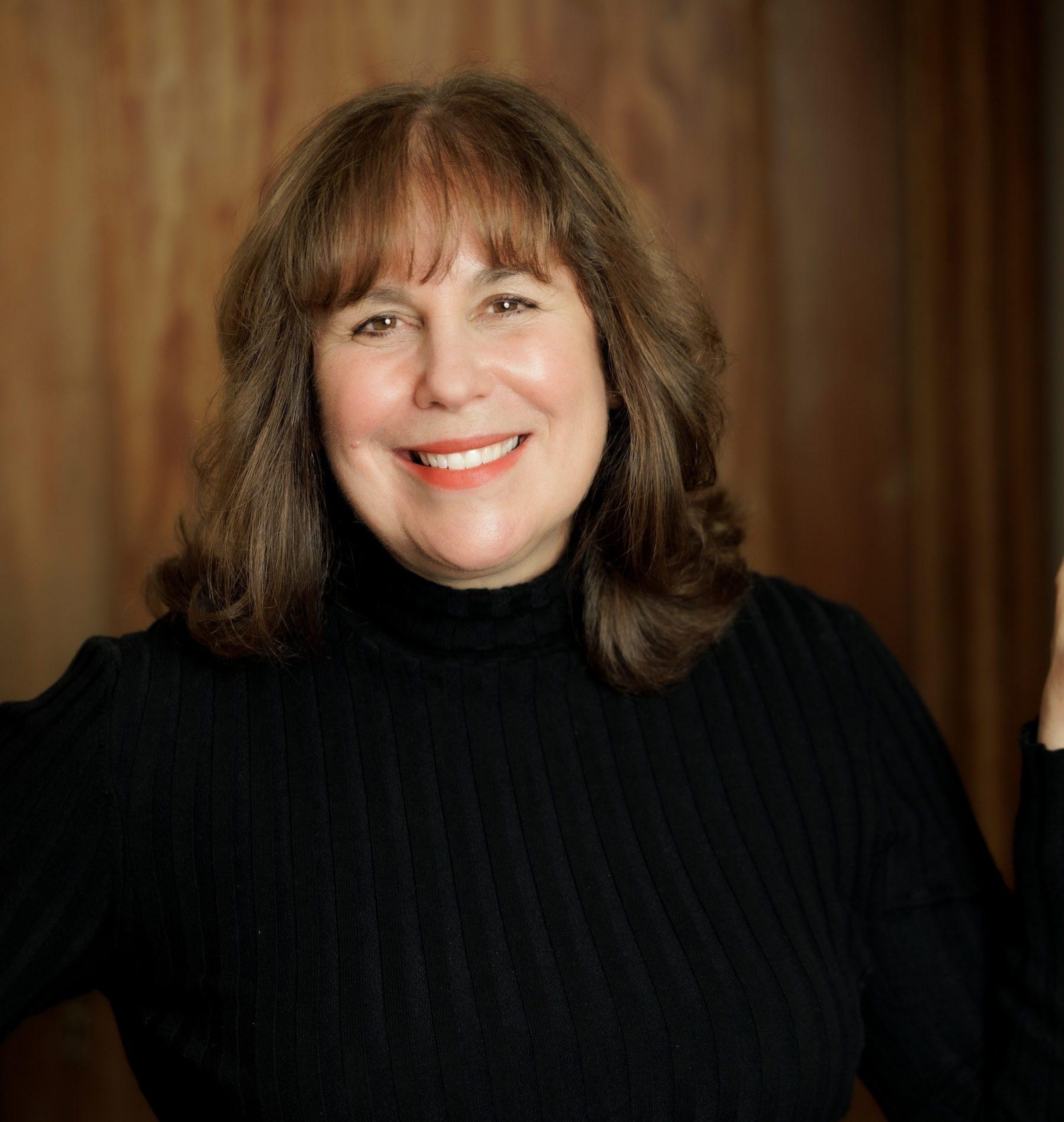 Rina Pantalony headshot in black turtleneck sweater with right hand on hip