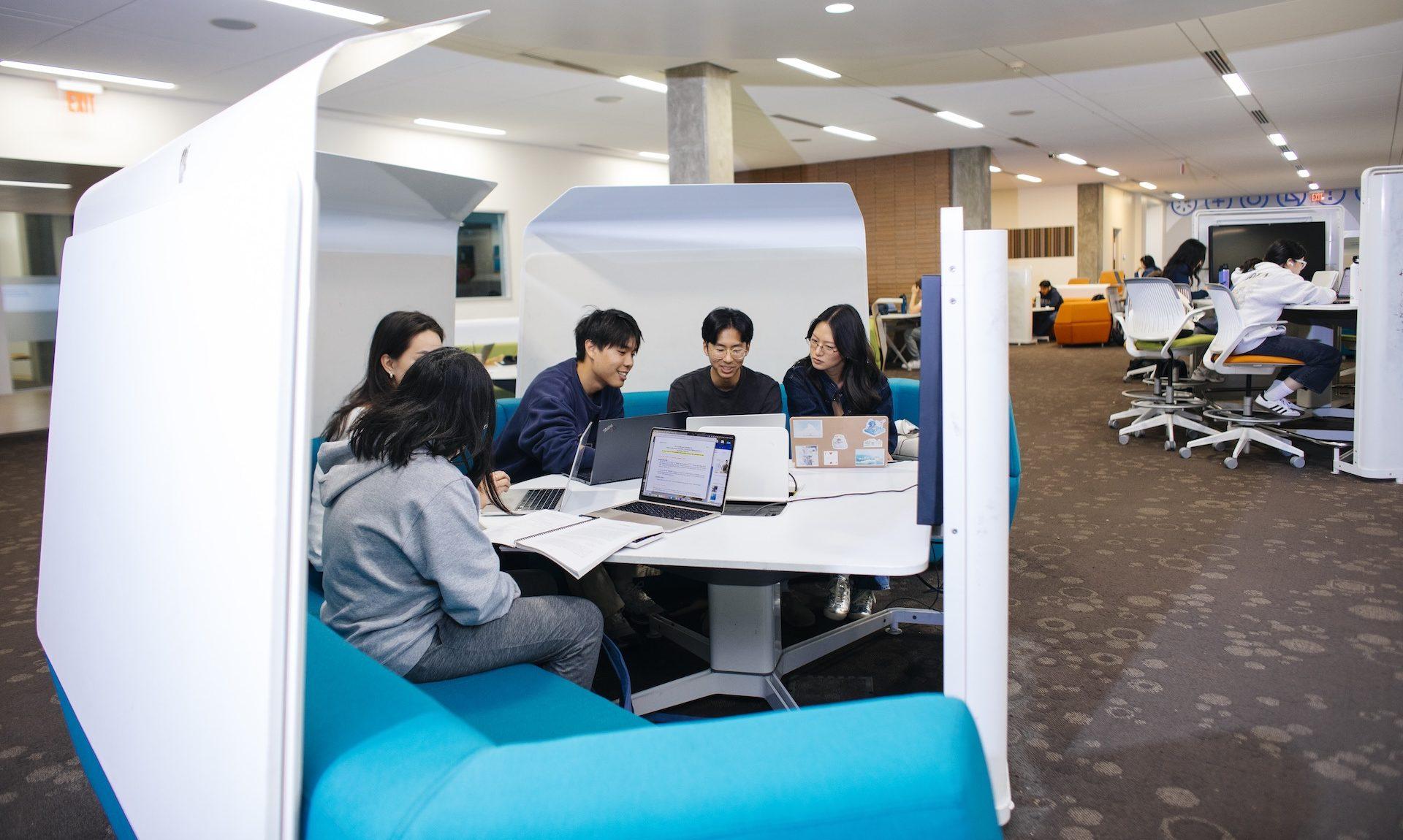 Students studying in the Charles E. Young Research Library collaboration pods