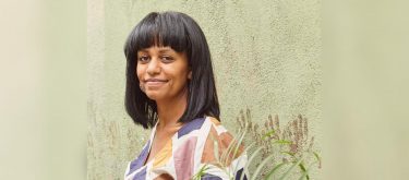 Nesanet Teshager Abegaze stands in front of green wall