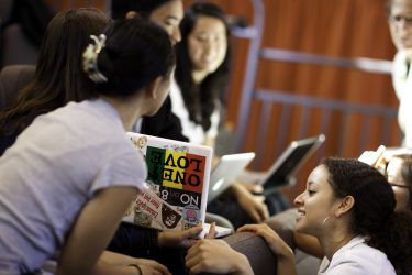 students looking at laptops on campus