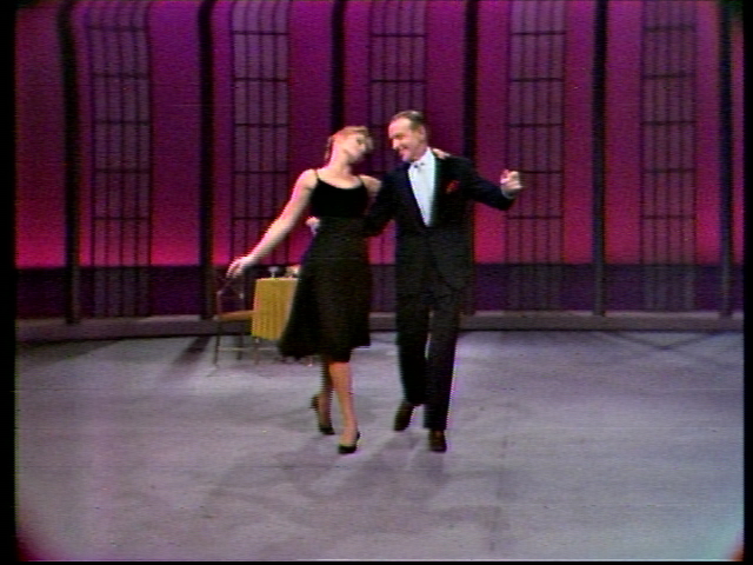 Man in black suit and woman in black dress dancing