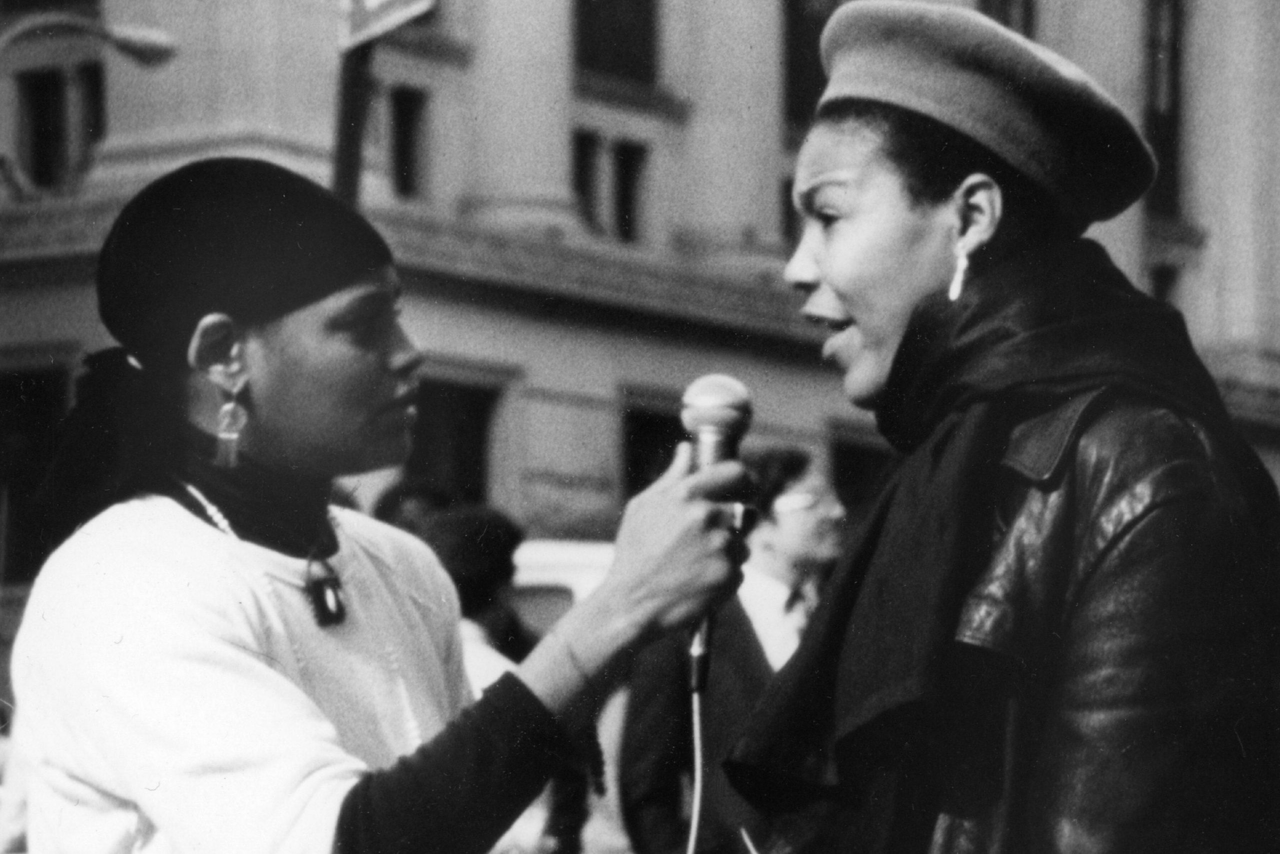 a black and white image of a woman interviewing another woman