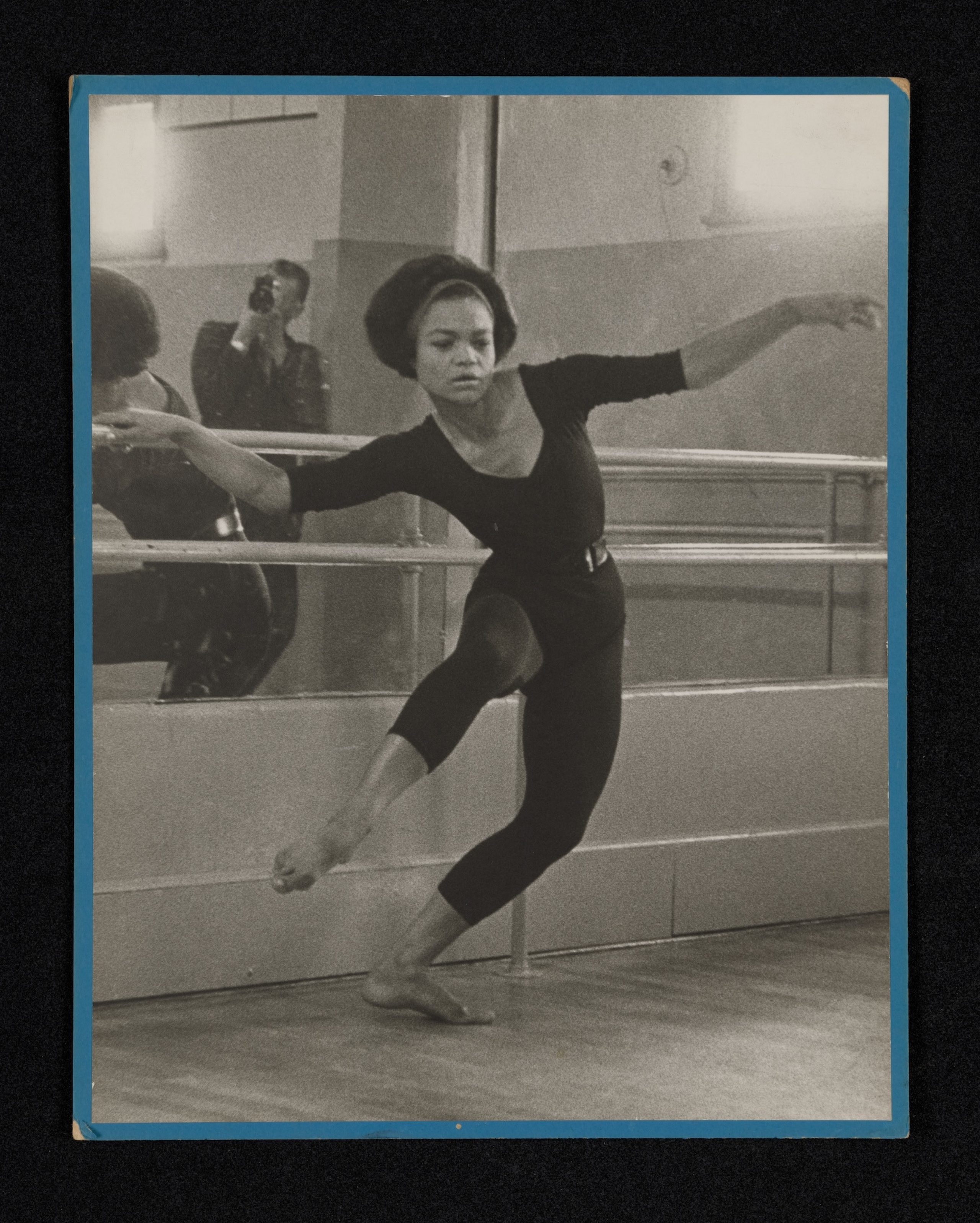Black and white photography of dancer Eartha Kitt with Howard Morehead reflected in a mirror behind her.