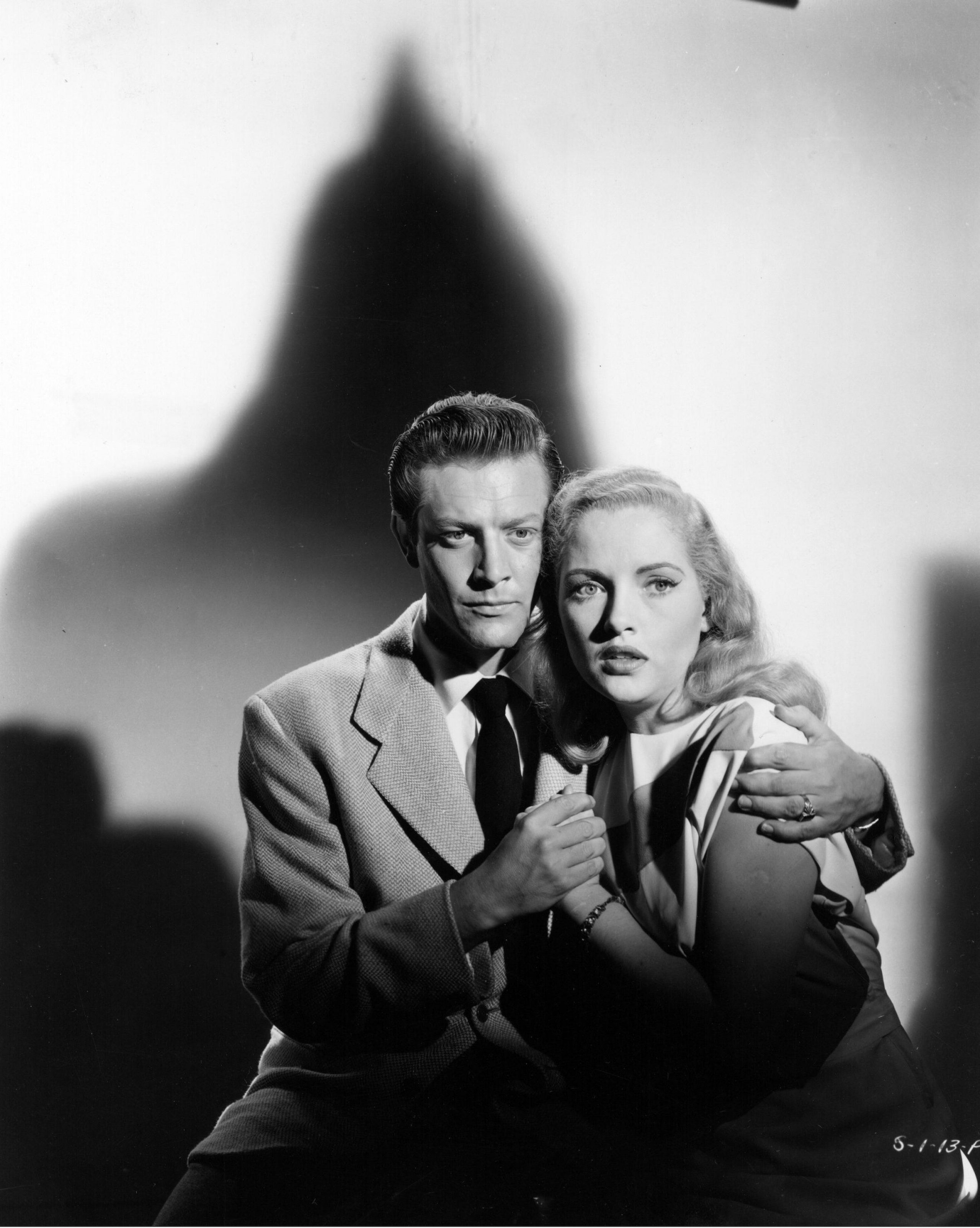 man and man huddling together while looking concerned