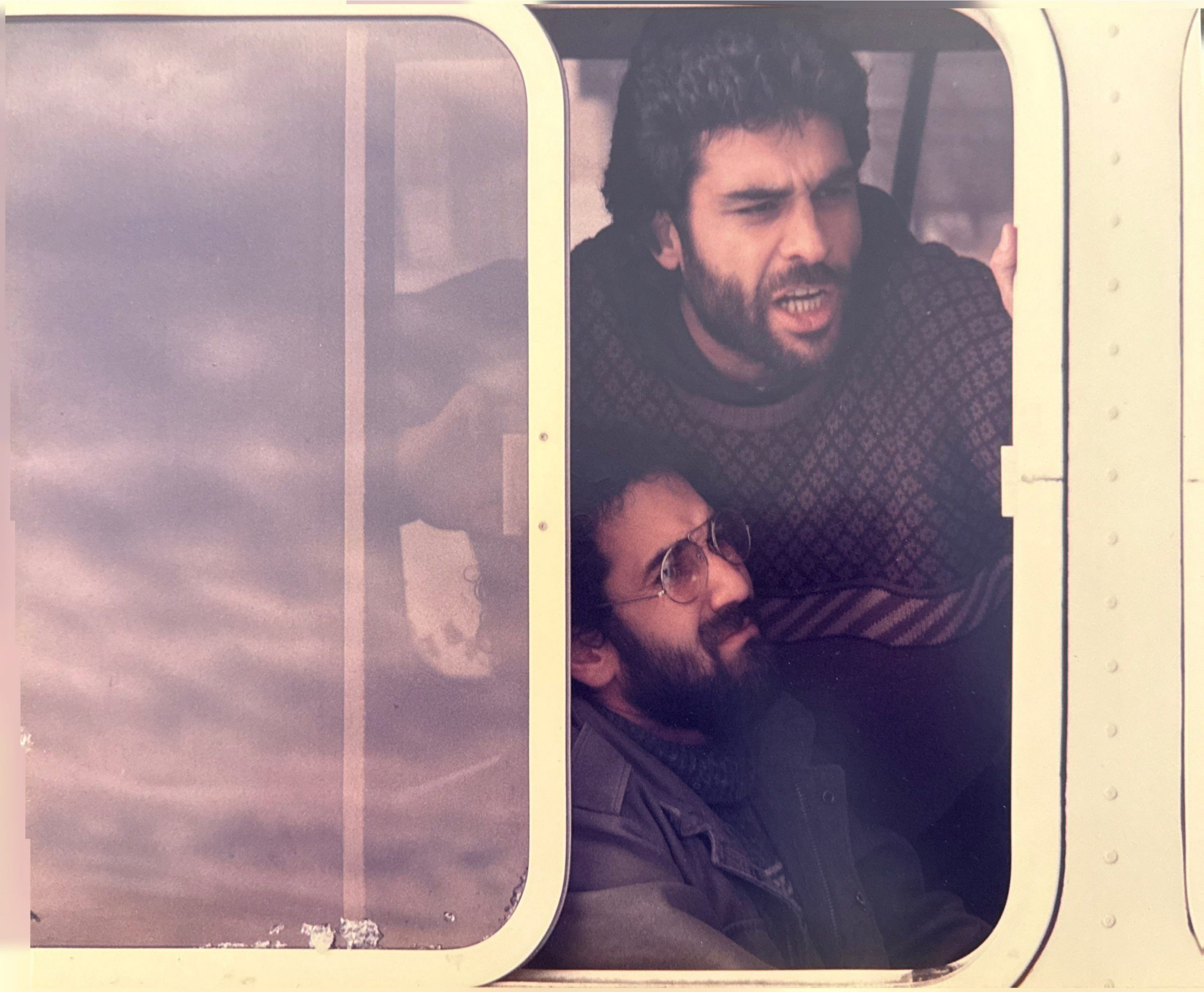 Two men showing distress in front of a sliding glass