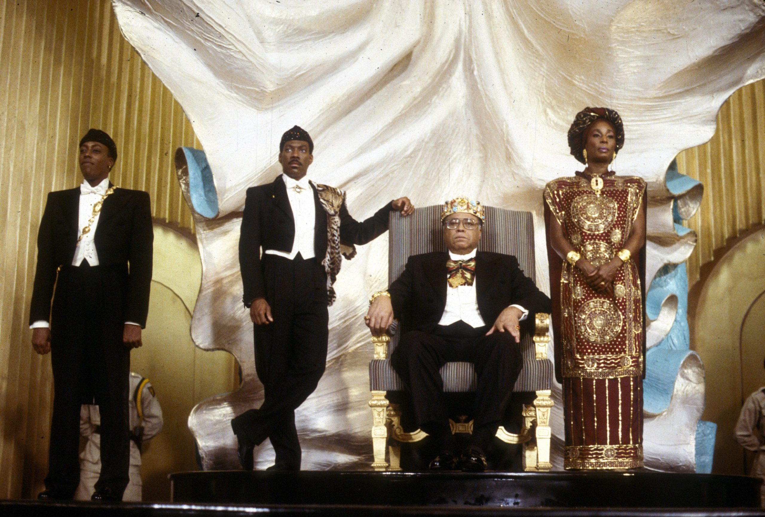 Still from the film "Coming to America". Four African Americans depicted next to each other in royal and luxurious attire.