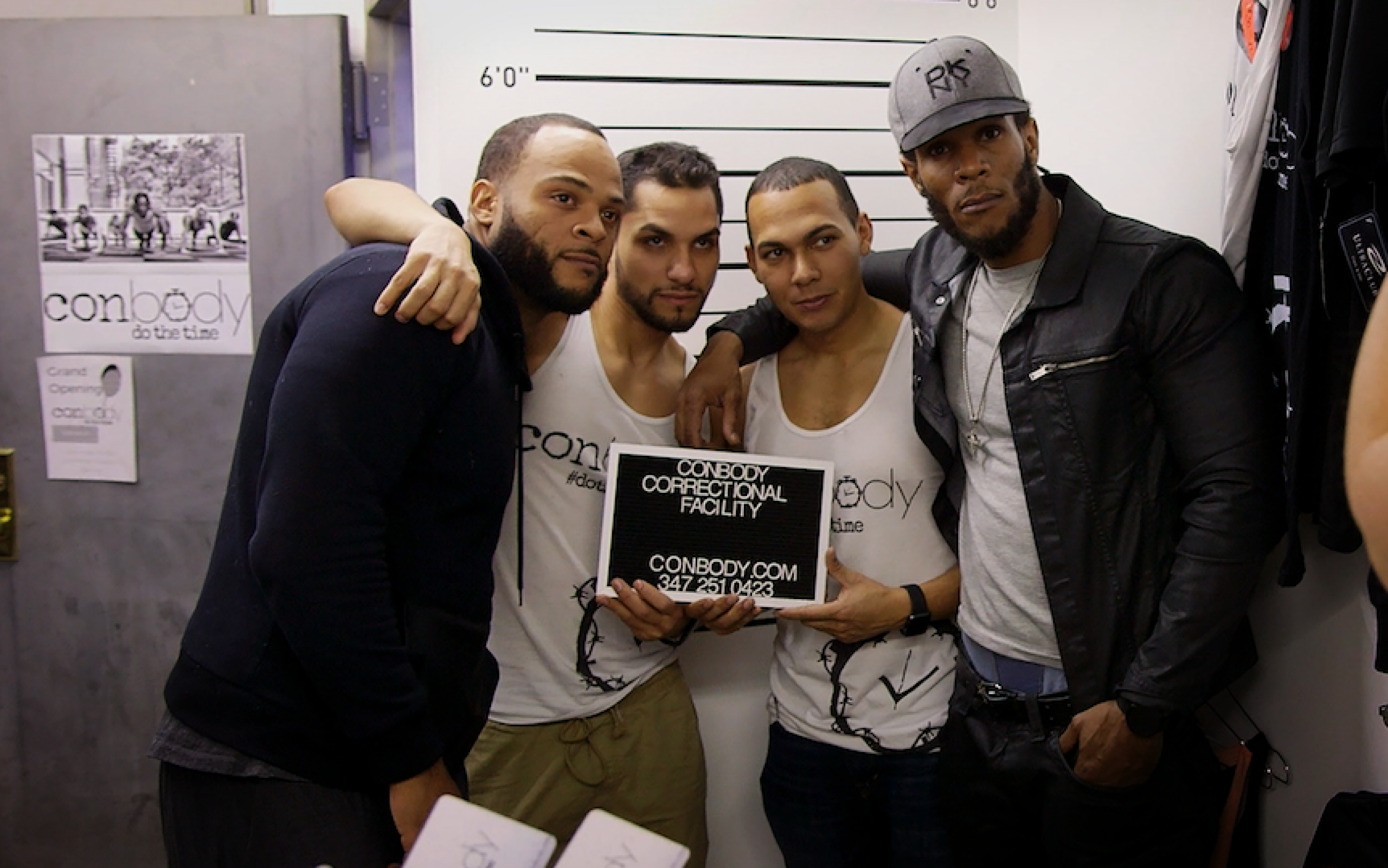 four men standing together holiding up a correctional facility sign