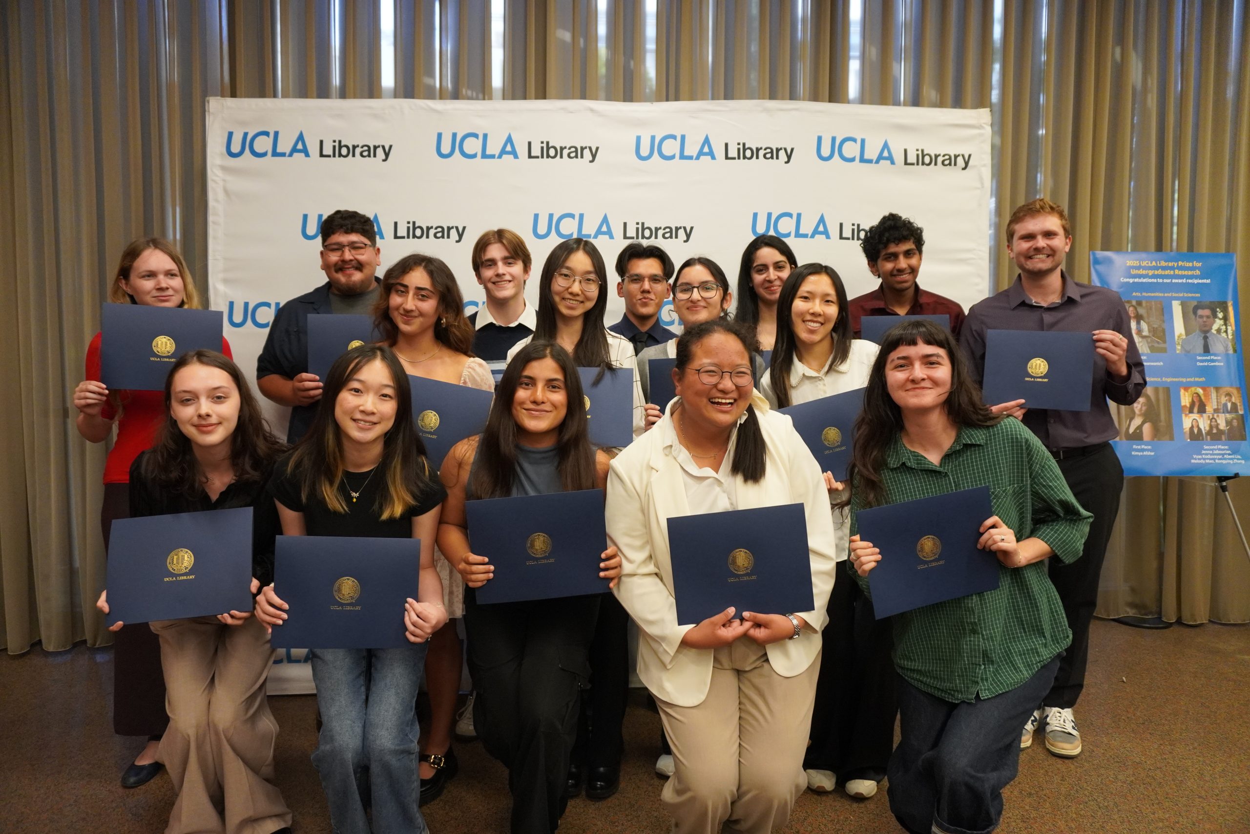 Library Prize student winners assembled in front of a UCLA Library step and repeat