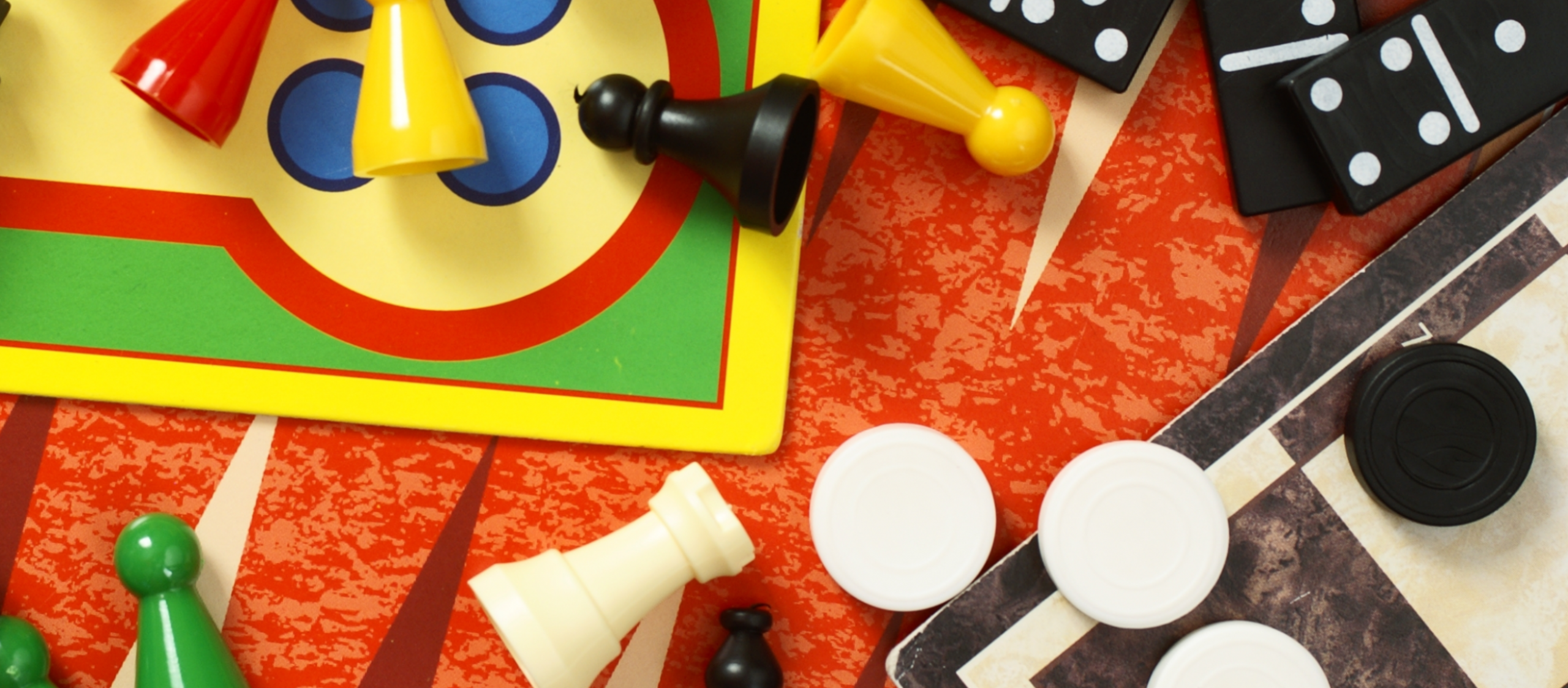 a selection of cards and game pieces, including parchees, checkers and dice