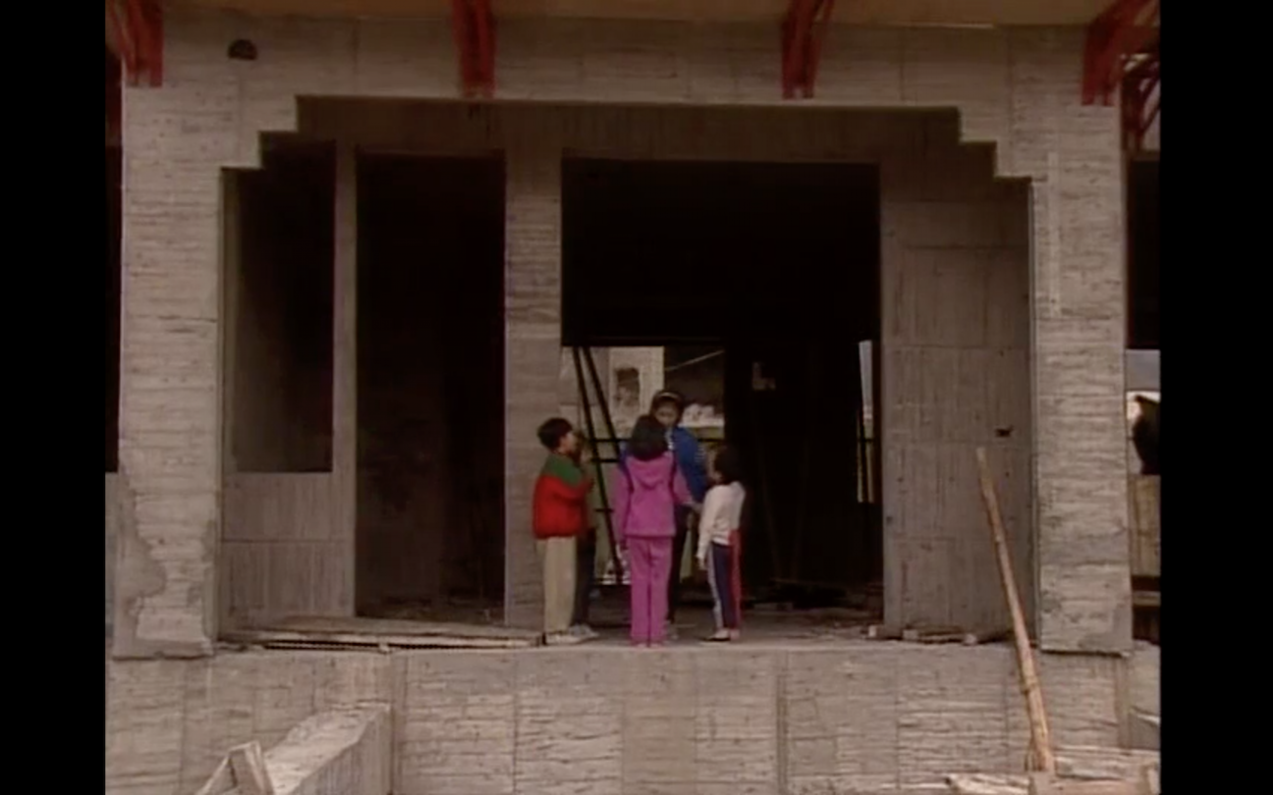 Four children standing in front of an unfinished building