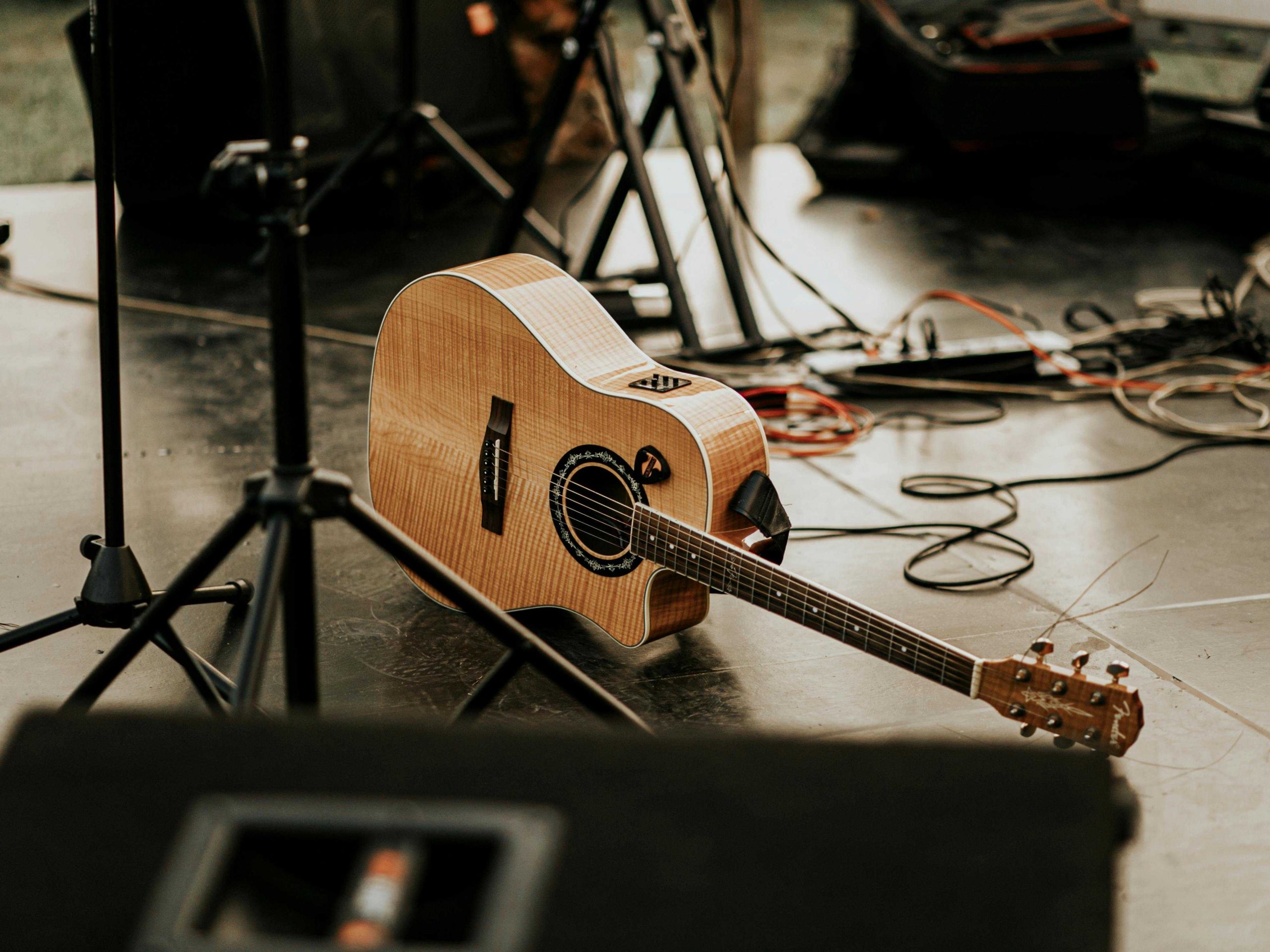 Guitar on stage with other audio equipment and instruments