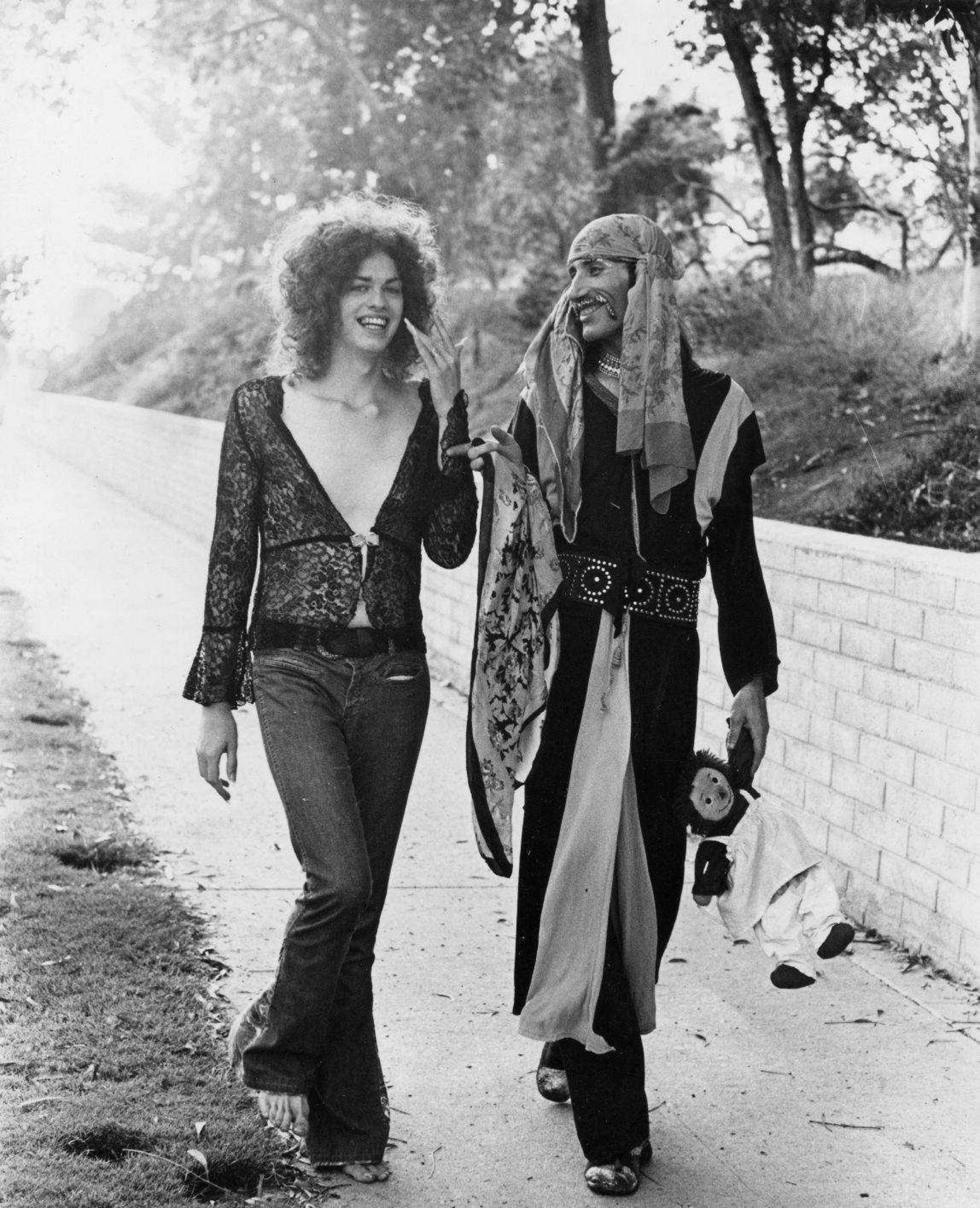 Black & white still from “Hats Off to Hollywood.” Characters walking along the street together