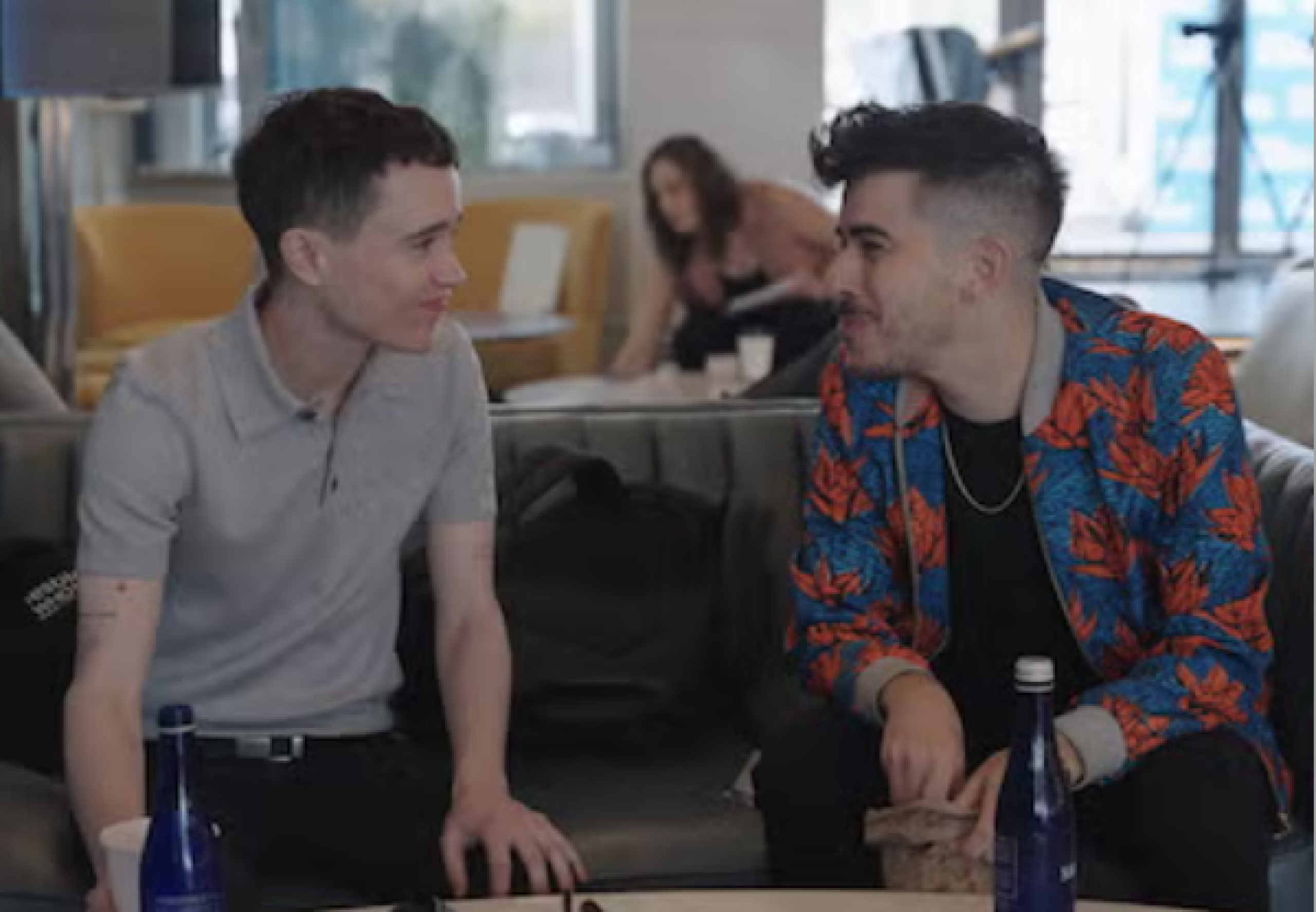 Two people sitting on a sofa looking and smiling at each other