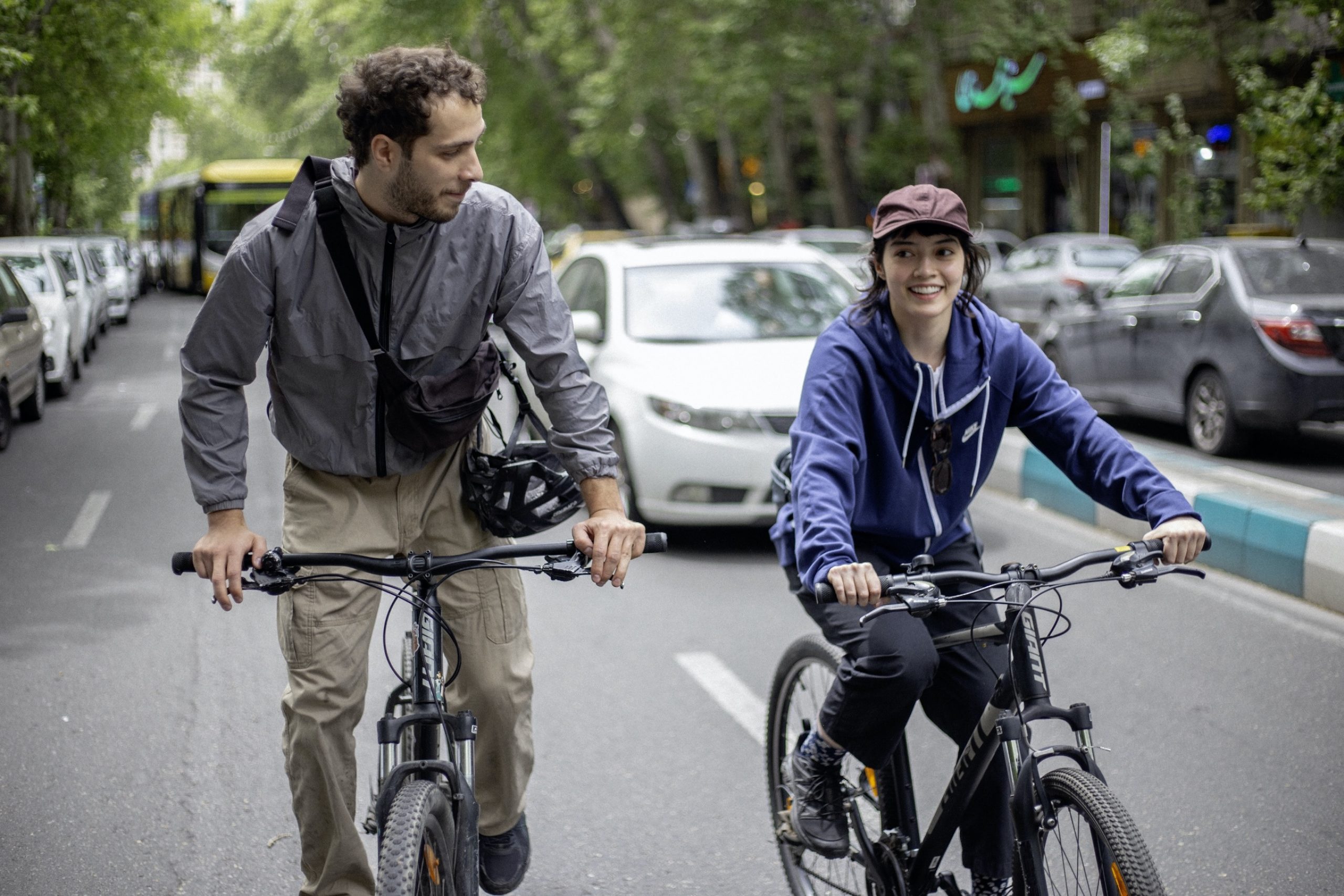 Man and young adult riding bicycles in the street