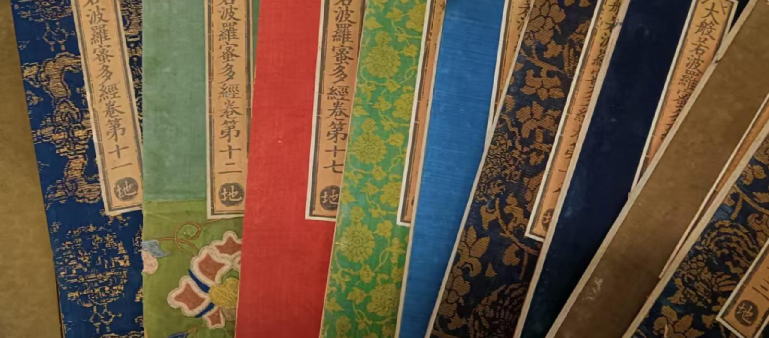 collection of colorful Buddhist texts fanned in a row