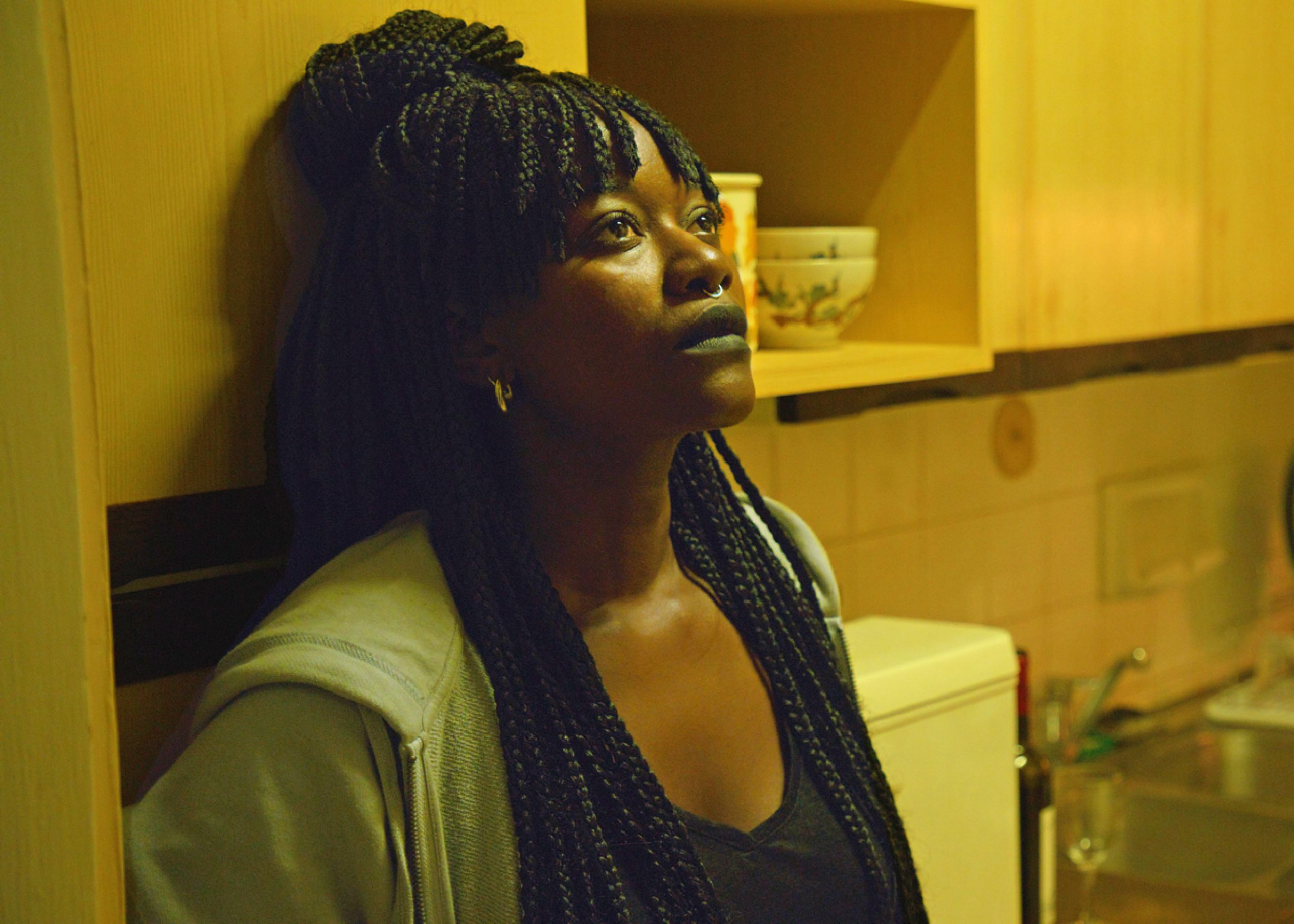 A woman in distress with her back against the wall
