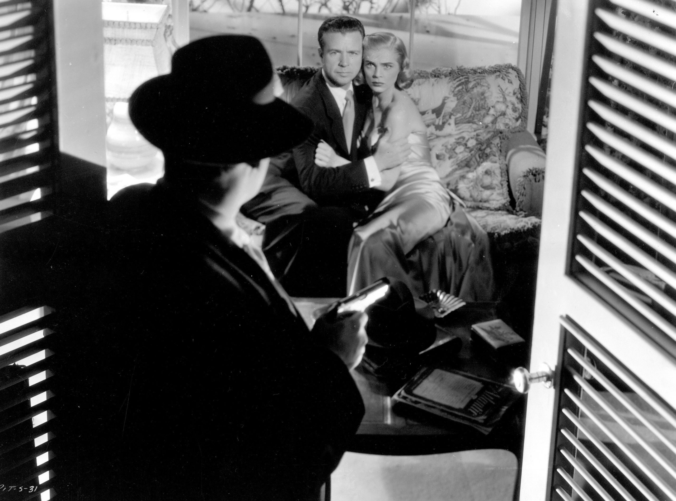 Still from Pitfall (couple stares at ominous man, from back view)