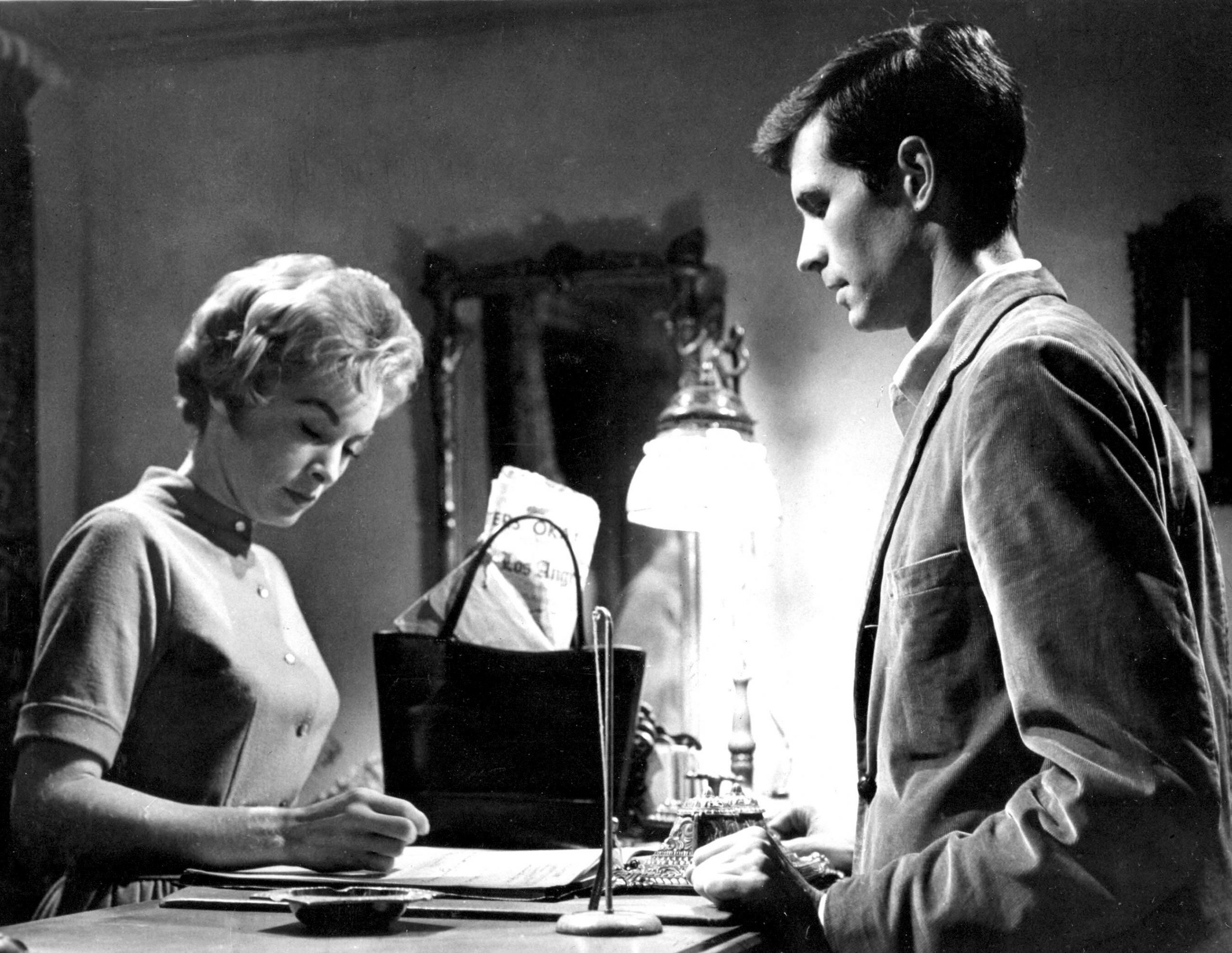 man standing in front of a woman at a desk