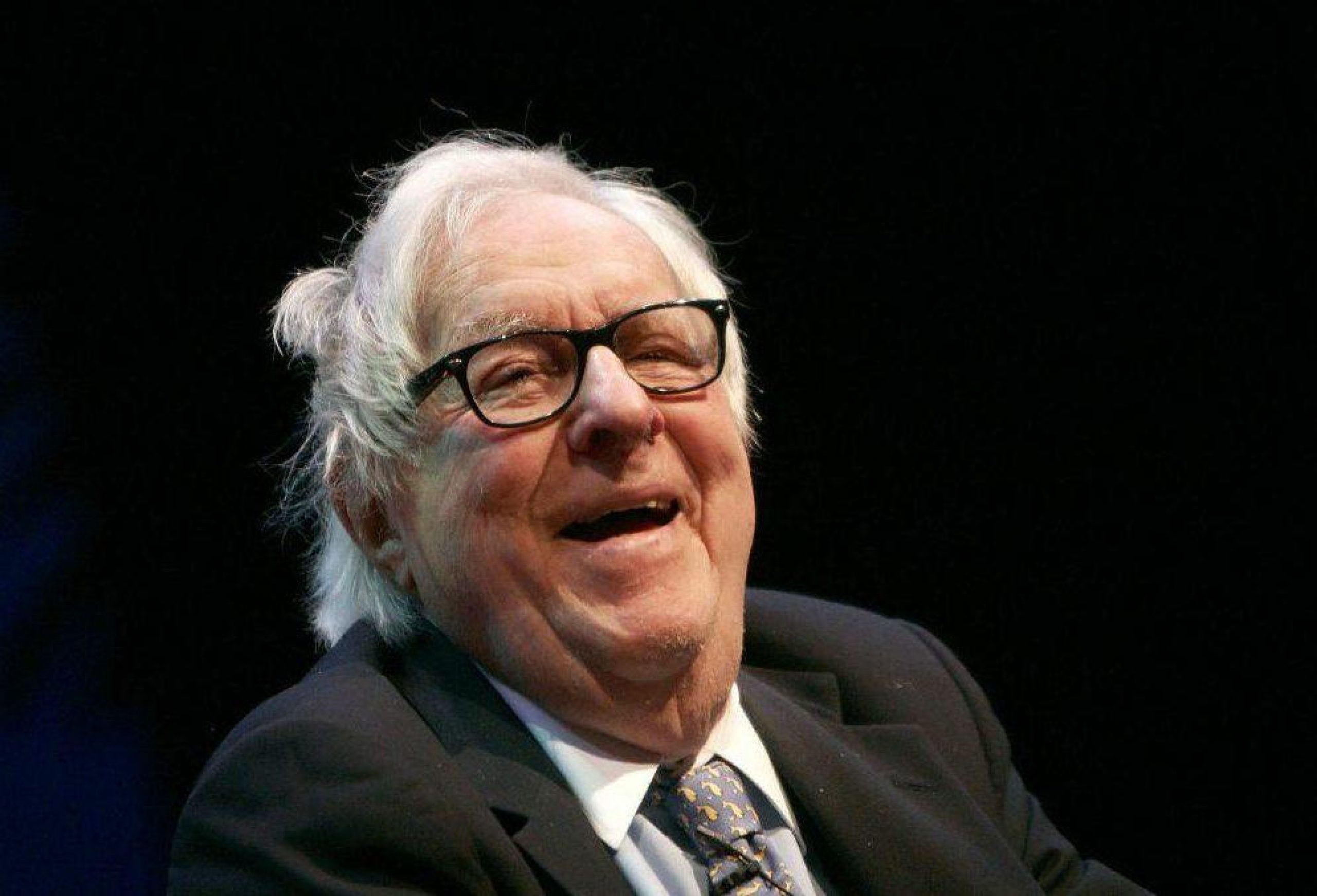 Ray Bradbury at UCLA in 2007, wearing a black suit, white shirt and tie and smiling at the camera