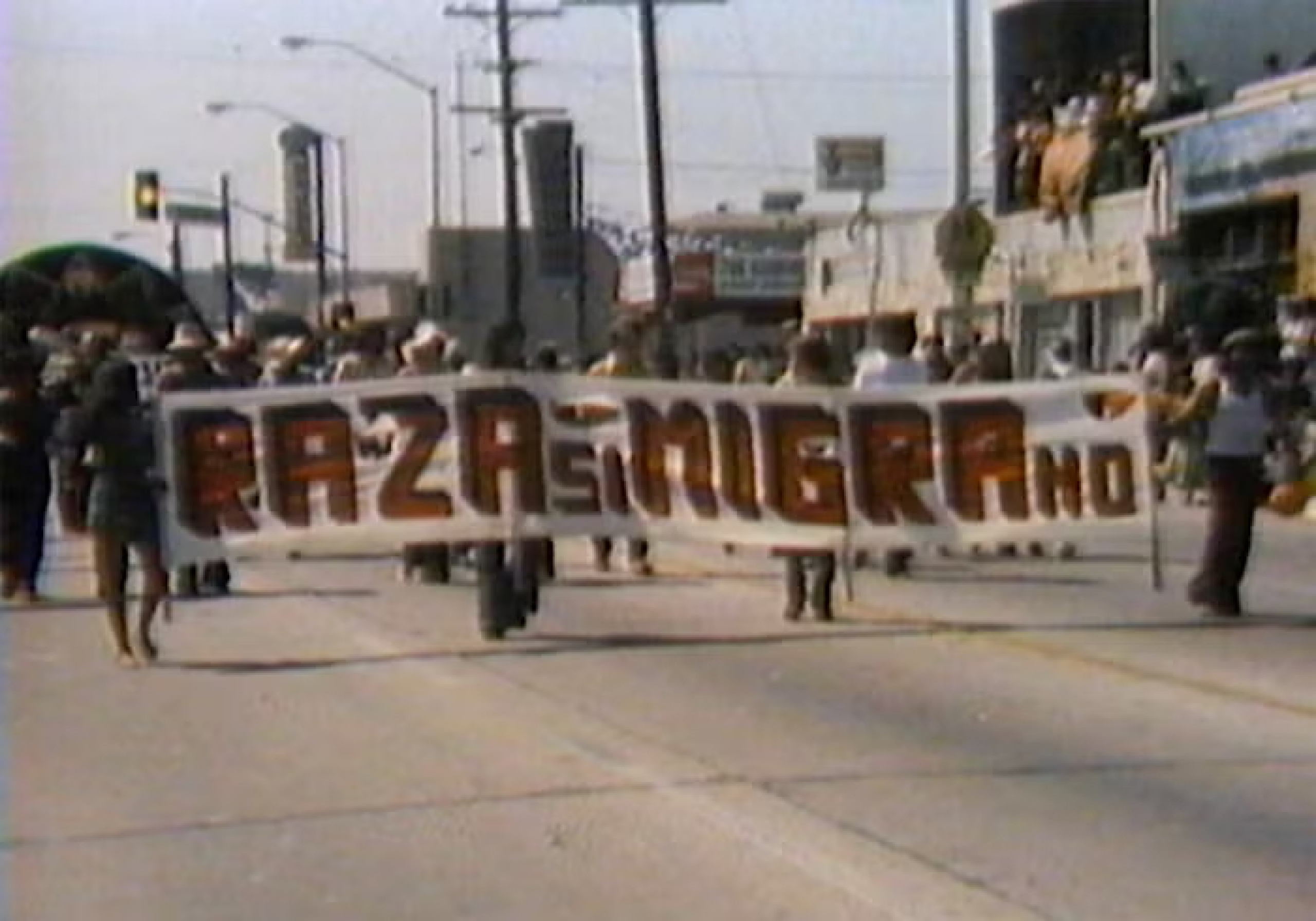 People marching with a Raza si Migra no sign