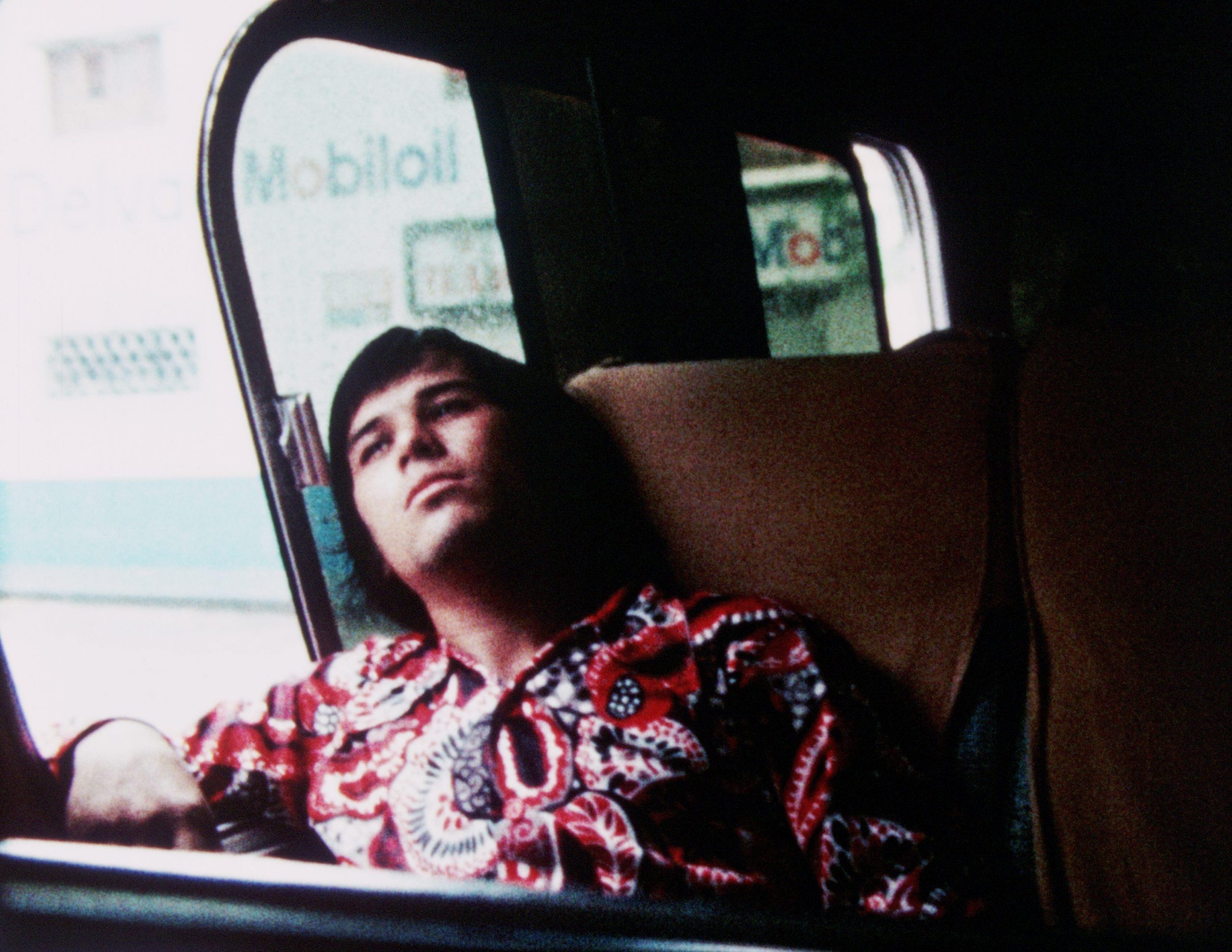 Man seated in a vehicle with head leaning back