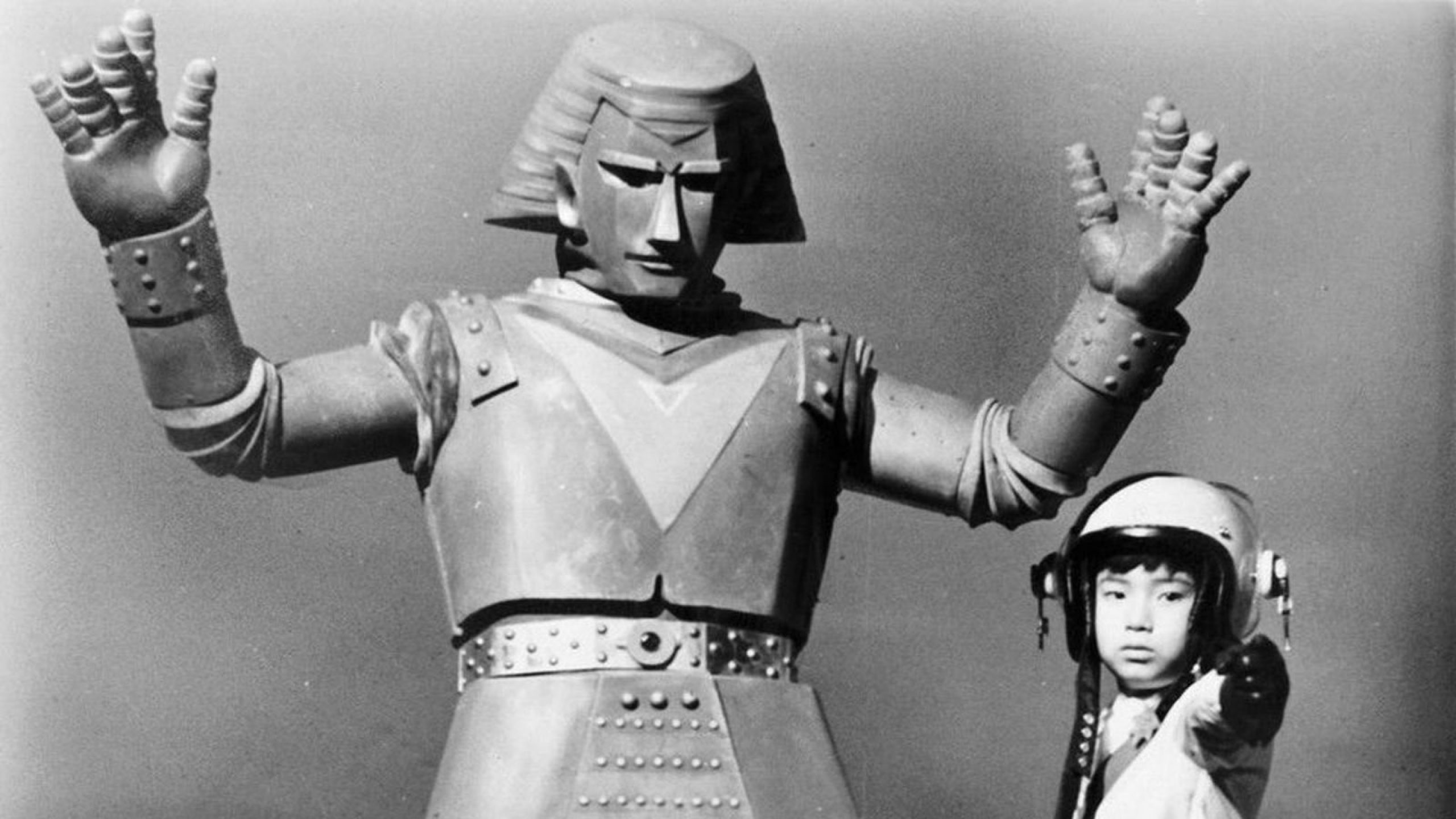 screenshot from johnny sokko and his flying robot (1967) featuring a little boy and tall robot