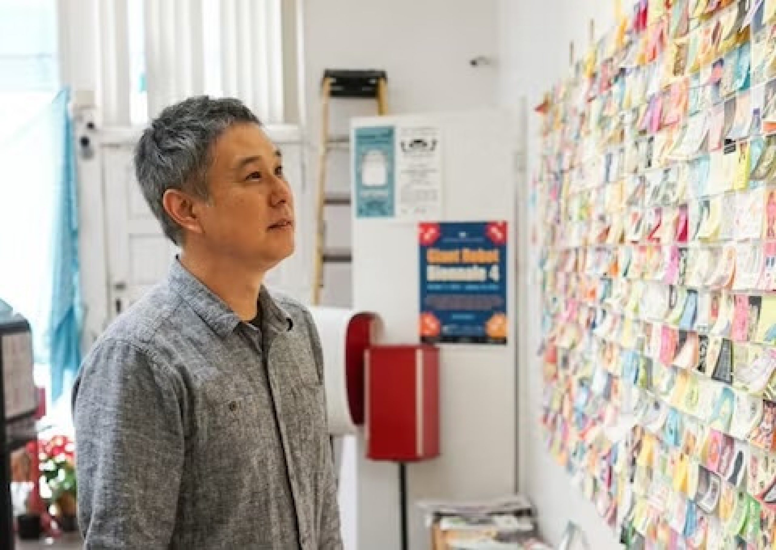 Eric Nakamura looking at a wall of art