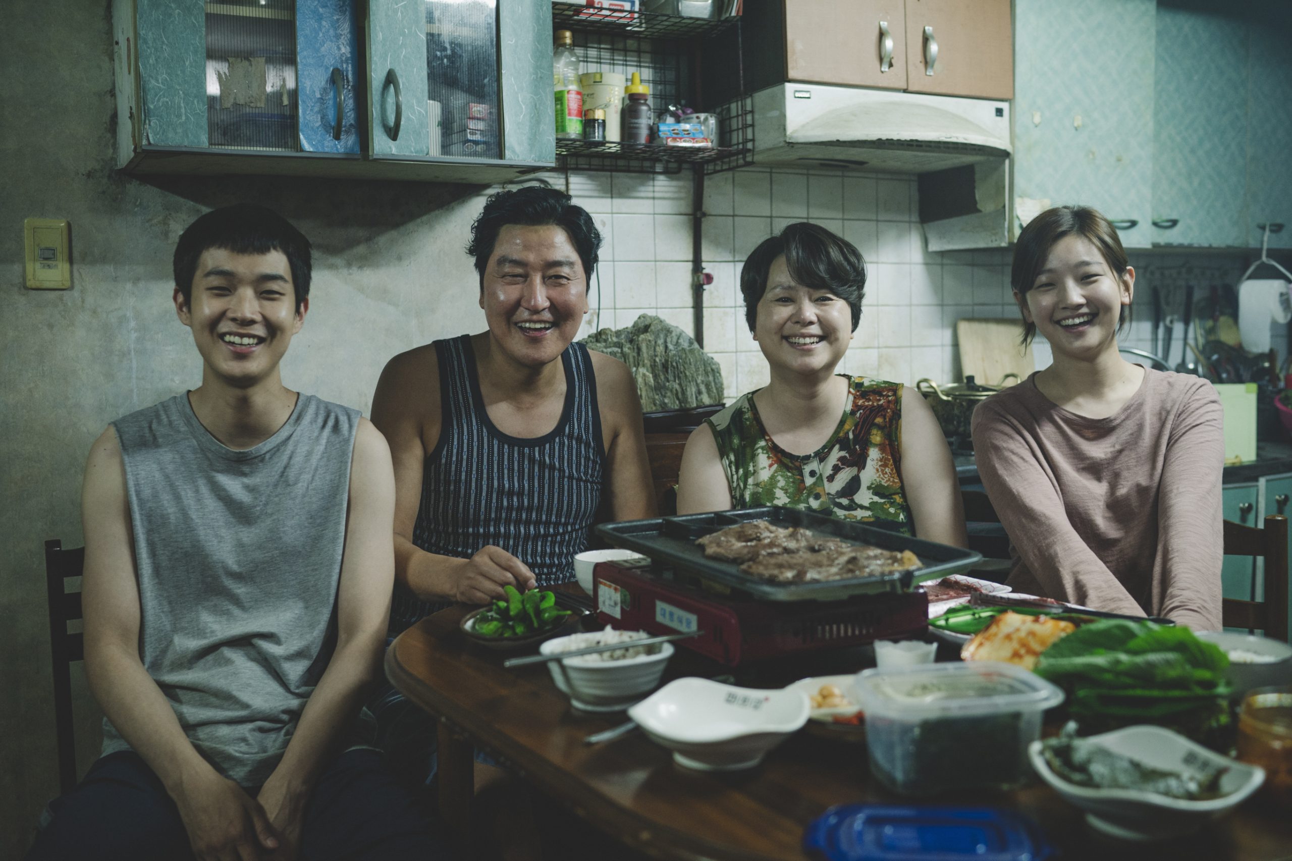 father, mother, son and daughter from Parasite film smiling at the camera
