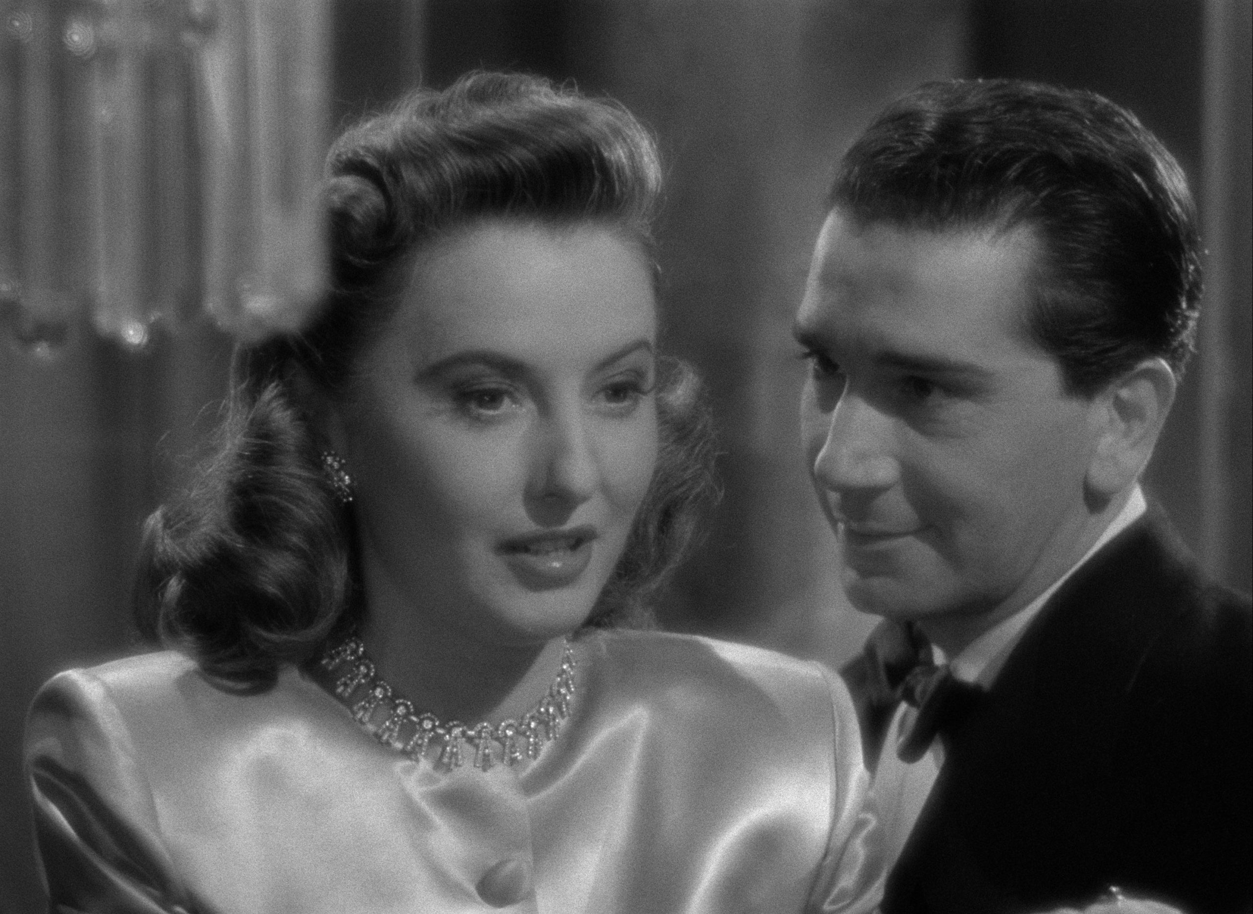 Still from The Other Love (man in suit gazing at woman next to him, who is looking away)