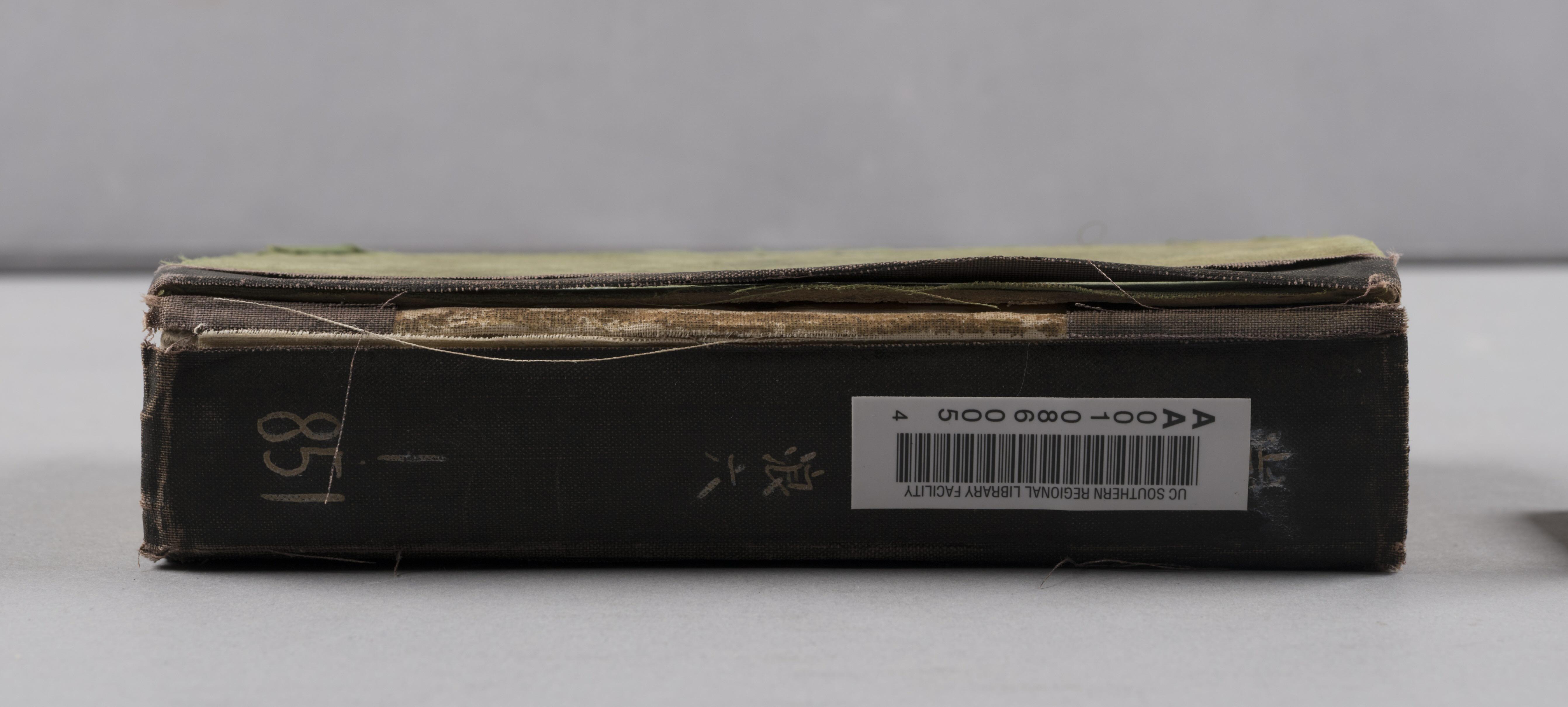 Cloth spine tape with handwritten title, call number, SLF-S barcode, and broken joint from Shakai hōshi no shikata / Nishikawa Kōjirō cho.社會奉仕の仕方 / 西川光二郎著.
